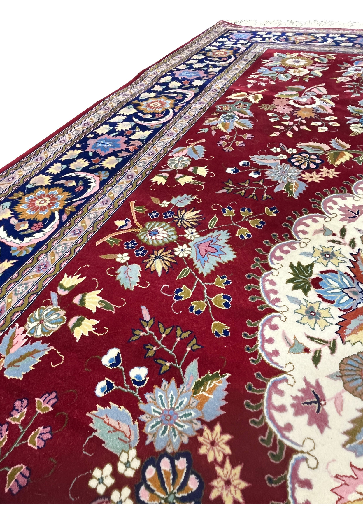 Color close-up of Persian Isfahan rug highlighting burgundy red, ivory, navy, and pastel floral tones