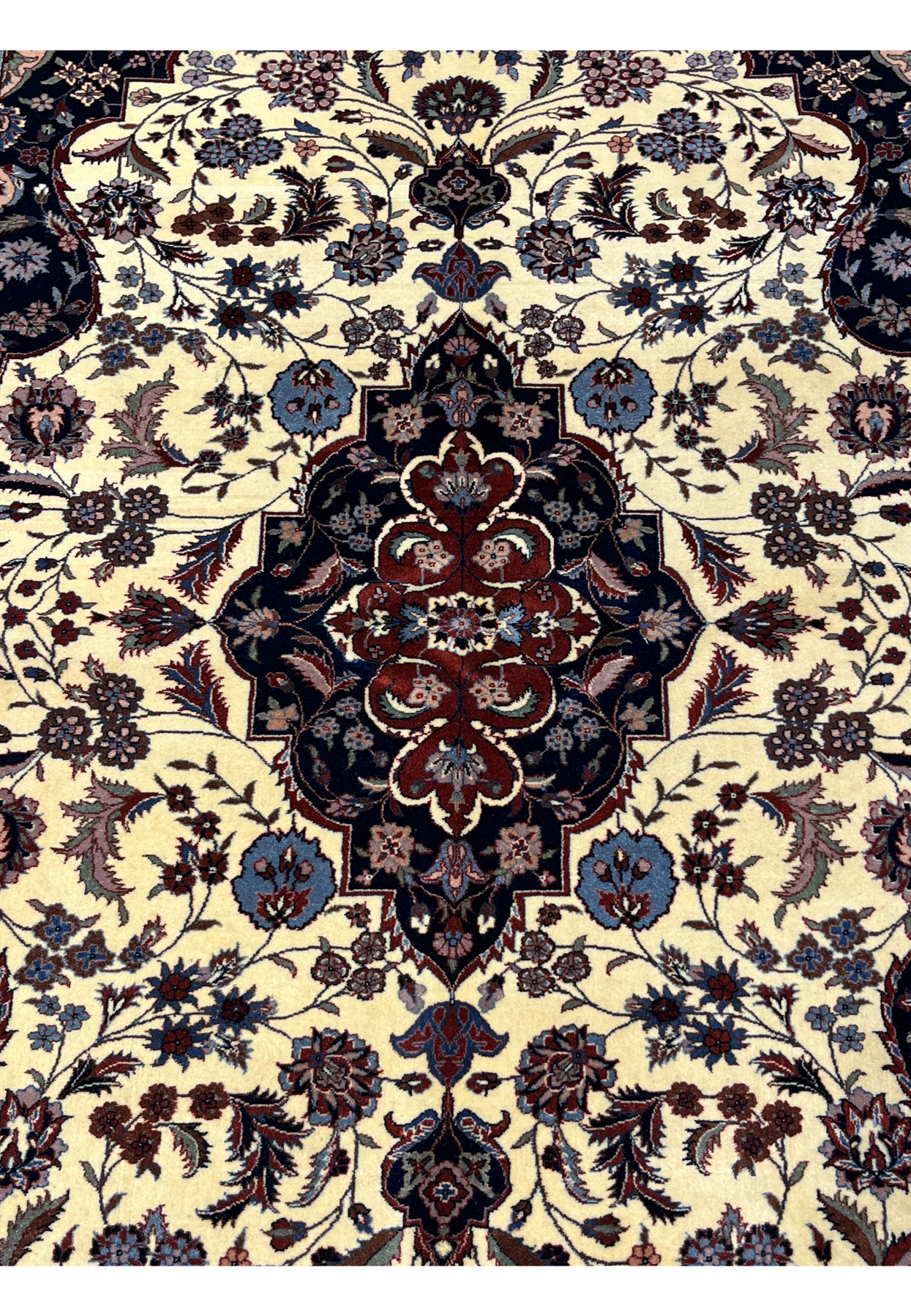 Persian Tabriz rug central medallion with layered floral motifs in navy, burgundy, and steel blue on an ivory background