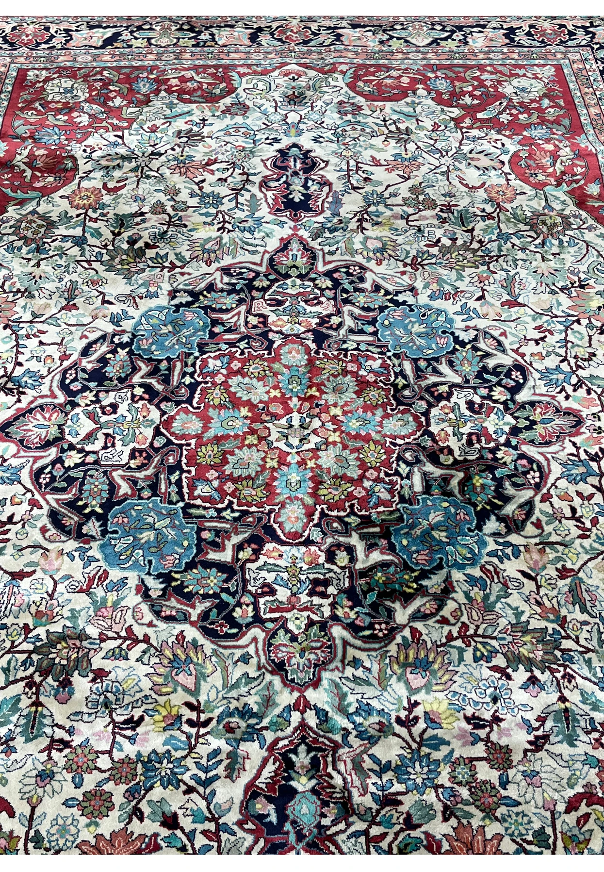 Midfield floral detailing on finely woven silk oriental rug