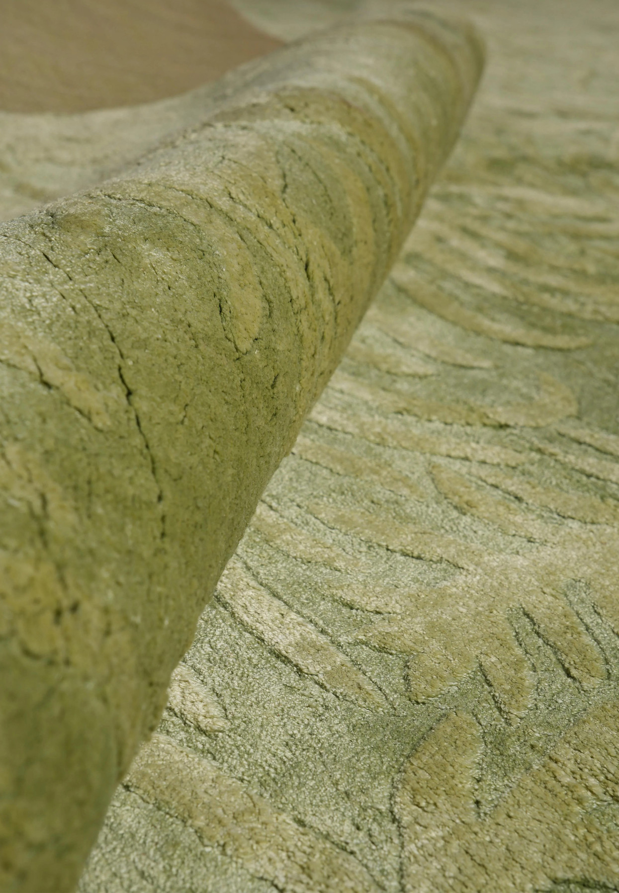 Folded corner image displaying the plush texture and layered green tones created by wool and silk fibers.