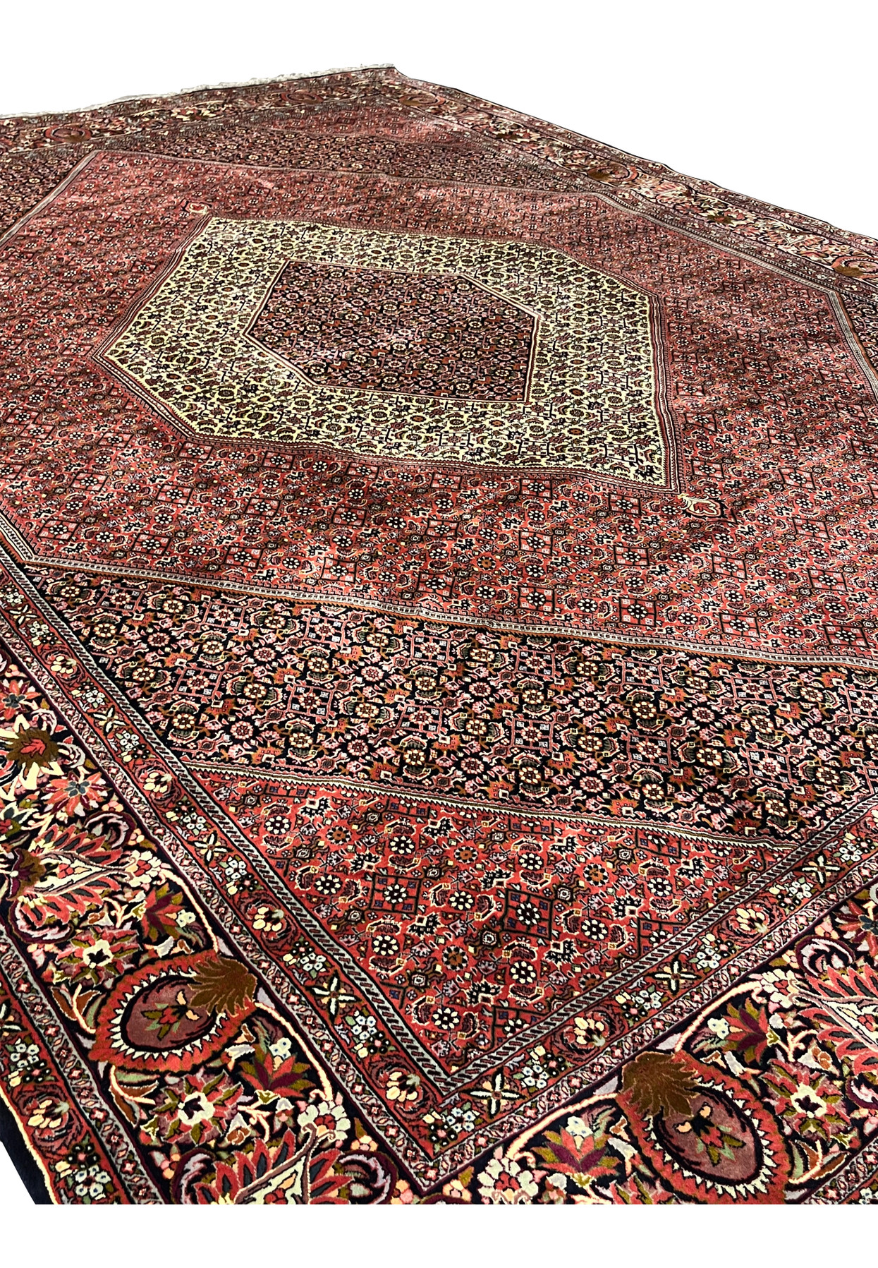 Perspective view highlighting the scale, symmetry, and deep red tones of a hand knotted Persian Bijar iron rug