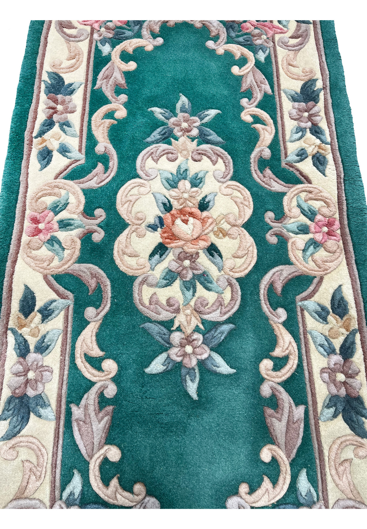 Macro view of raised floral scrollwork on Aubusson Art Deco rug highlighting sculpted weaving and dimensional surface texture