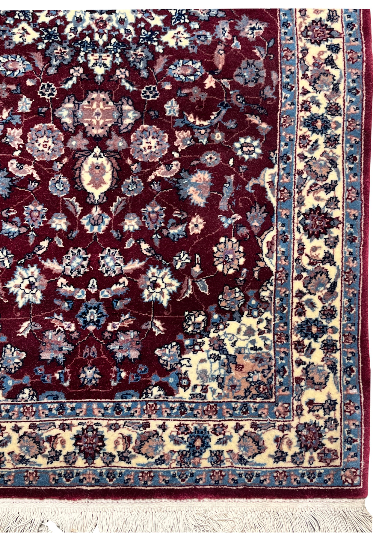 Border detail of a Persian Tabriz rug displaying an ivory ground with repeating floral vines, soft blue accents, and clean framing around the burgundy field