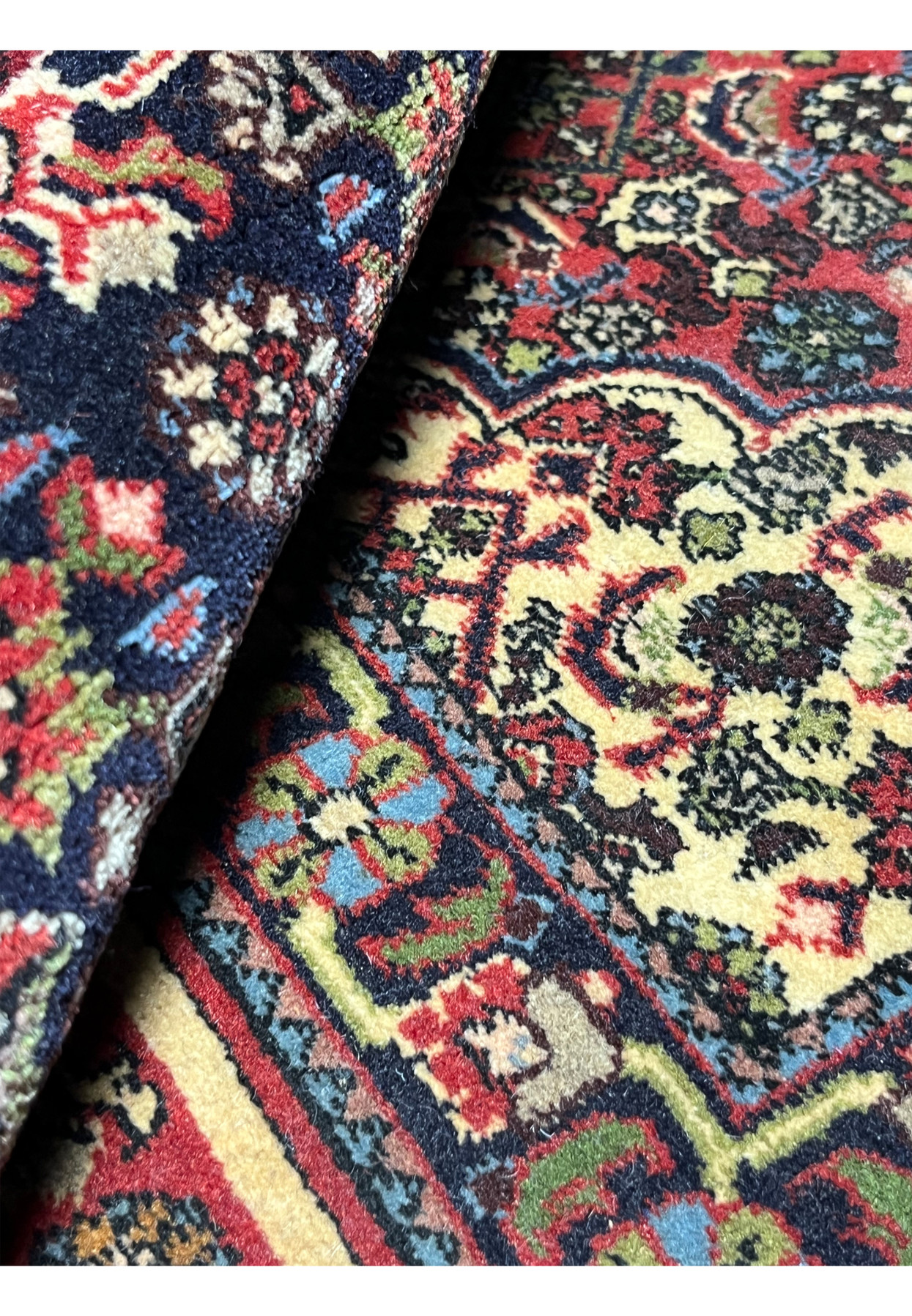 Rolled view of a Persian Bijar rug highlighting weight, flexibility, dense wool pile, and the solid construction associated with iron rugs