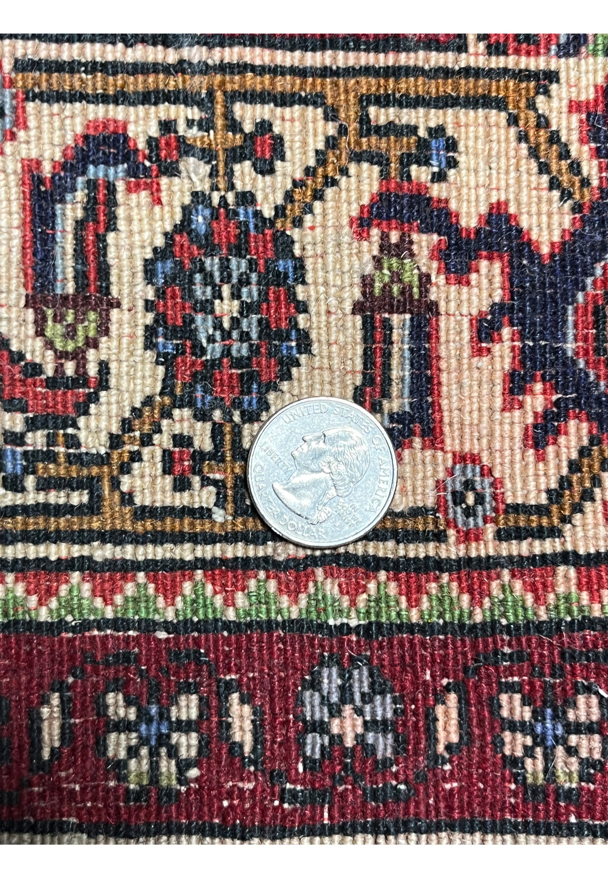 Close-up of the backside of a Persian Bijar rug with coin reference showing dense knot structure, compact weave, and high wool quality
