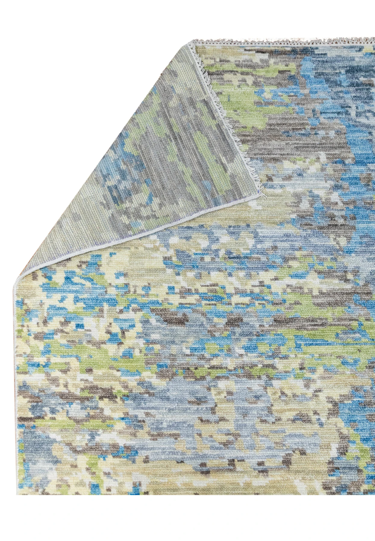 Folded corner detail of the modern Nepali abstract rug illustrating wool thickness, flexibility, and smooth edge binding with soft blue and ivory tones.
