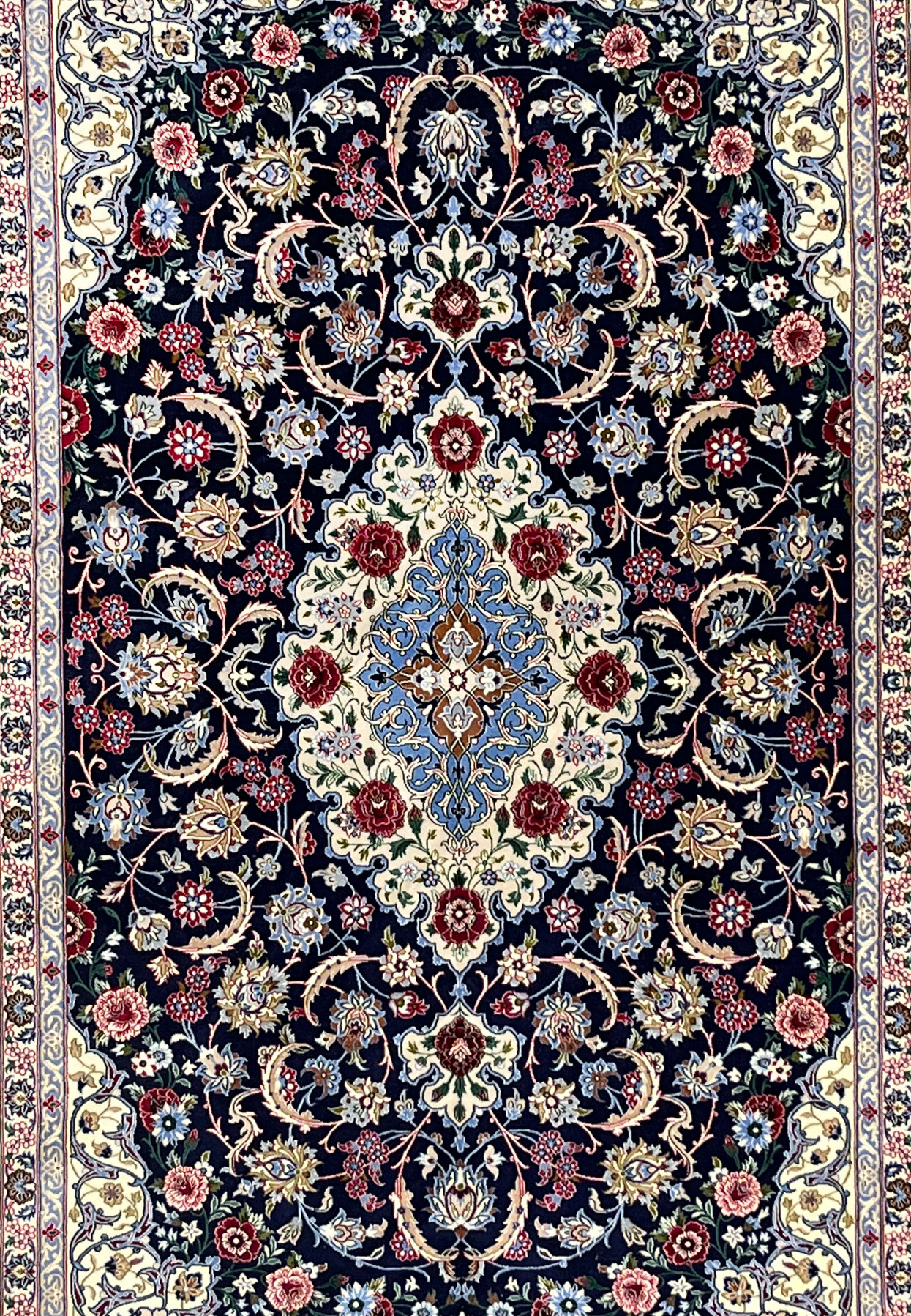 Central field of Persian Isfahan rug featuring ivory medallion, light blue arabesques, burgundy floral accents, and dense fine knot structure