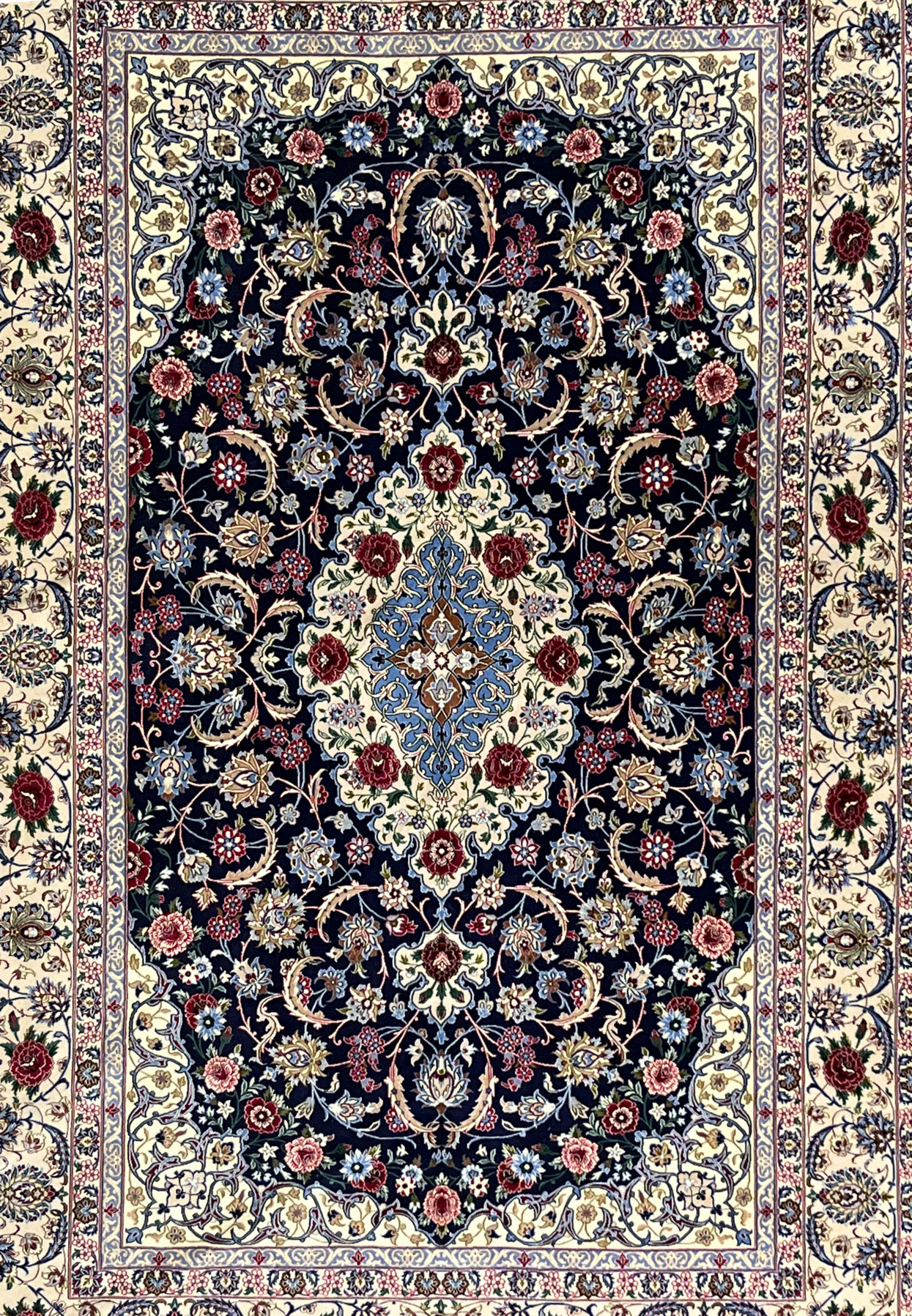 Midfield detail of super fine Persian Isfahan rug highlighting navy ground, scrolling floral vines, silk highlights, and precise hand knotted detailing