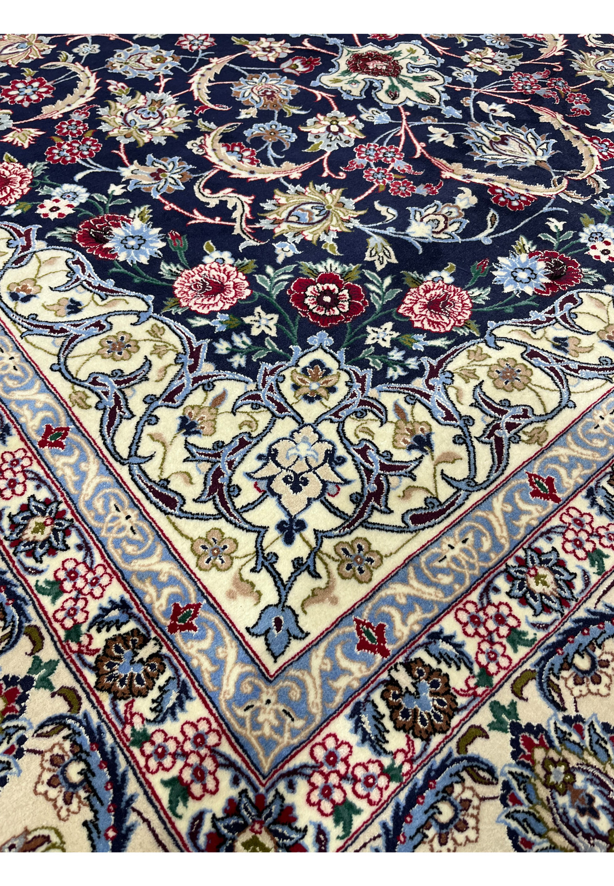 Inner border detail of a Persian Isfahan rug with delicate floral scrolls in powder blue, ivory, burgundy red, and muted green tones