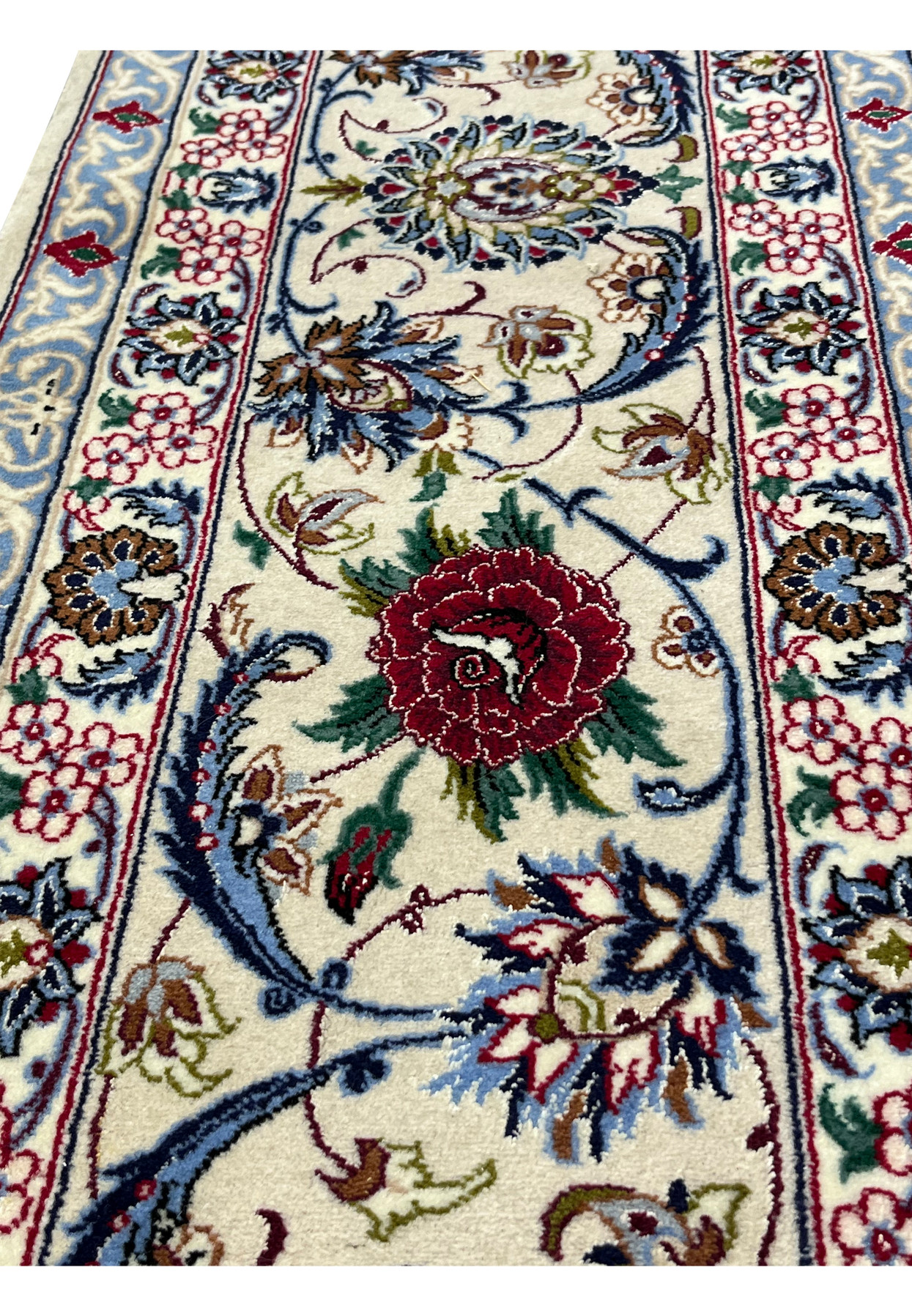 Zoomed border image of a Persian Isfahan rug showcasing crisp floral detailing, silk highlights, and a refined ivory and navy color balance
