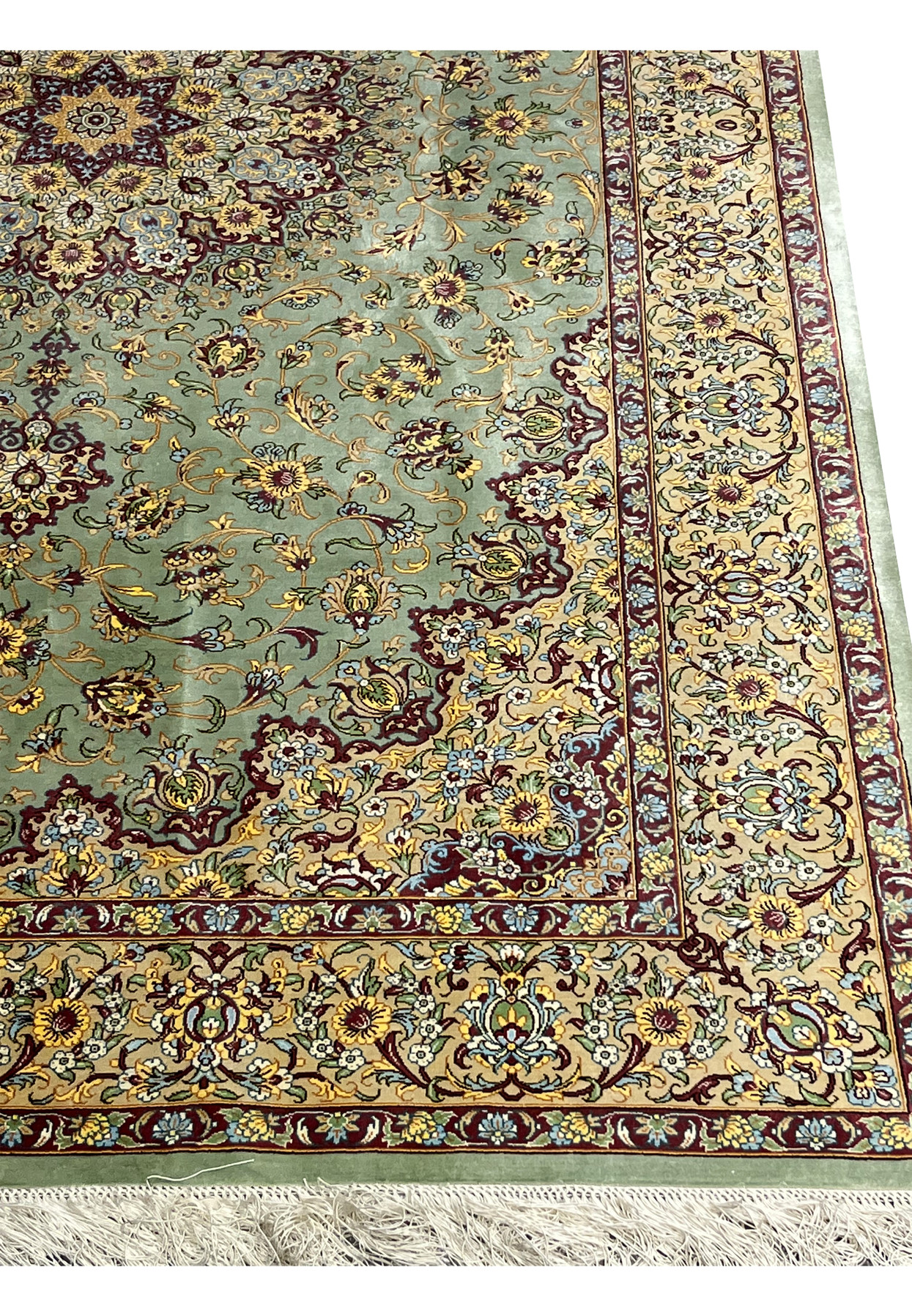 Close-up of the main border on a signed Mirmehdi Persian Qum silk rug with dense floral motifs, burgundy accents, and fine silk texture