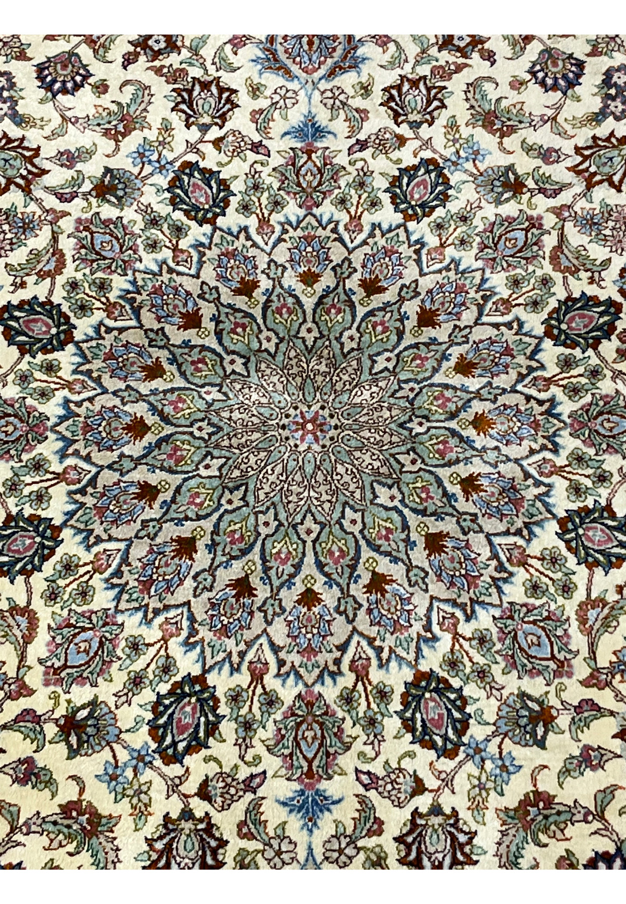 Close-up of the central medallion of a signed Persian Qum silk rug showing layered floral geometry, fine silk knotting, and balanced symmetrical design.