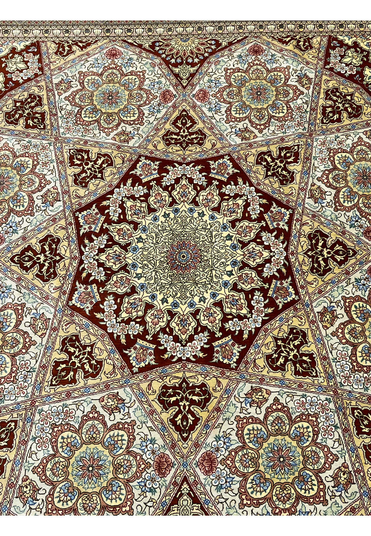 Close-up of the star medallion on a signed Amjadi Persian Qum silk on silk rug, revealing intricate floral detailing and precision weaving