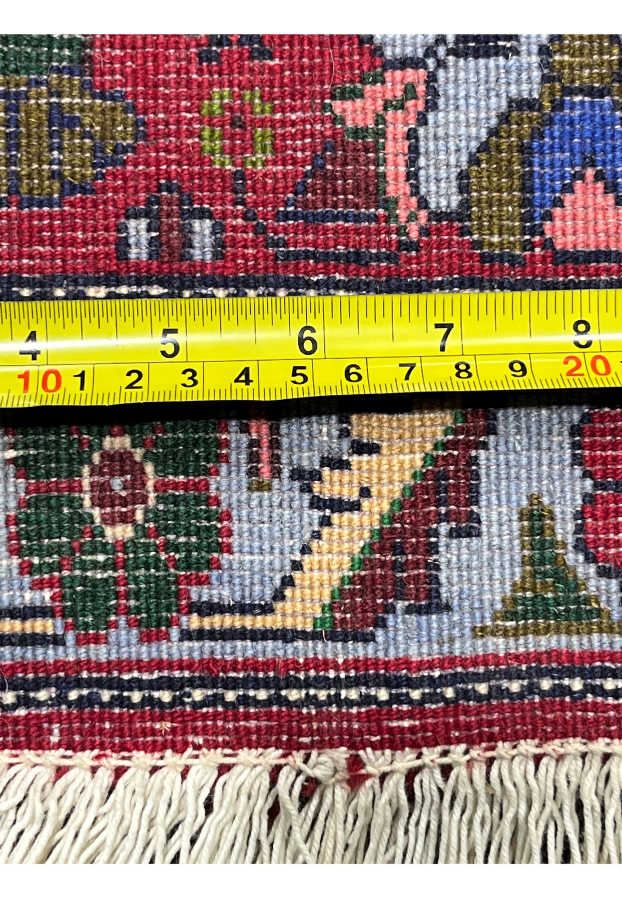 Backside view with ruler showing Persian Senneh rug knot density, even structure, precise scale, and tightly woven wool foundation