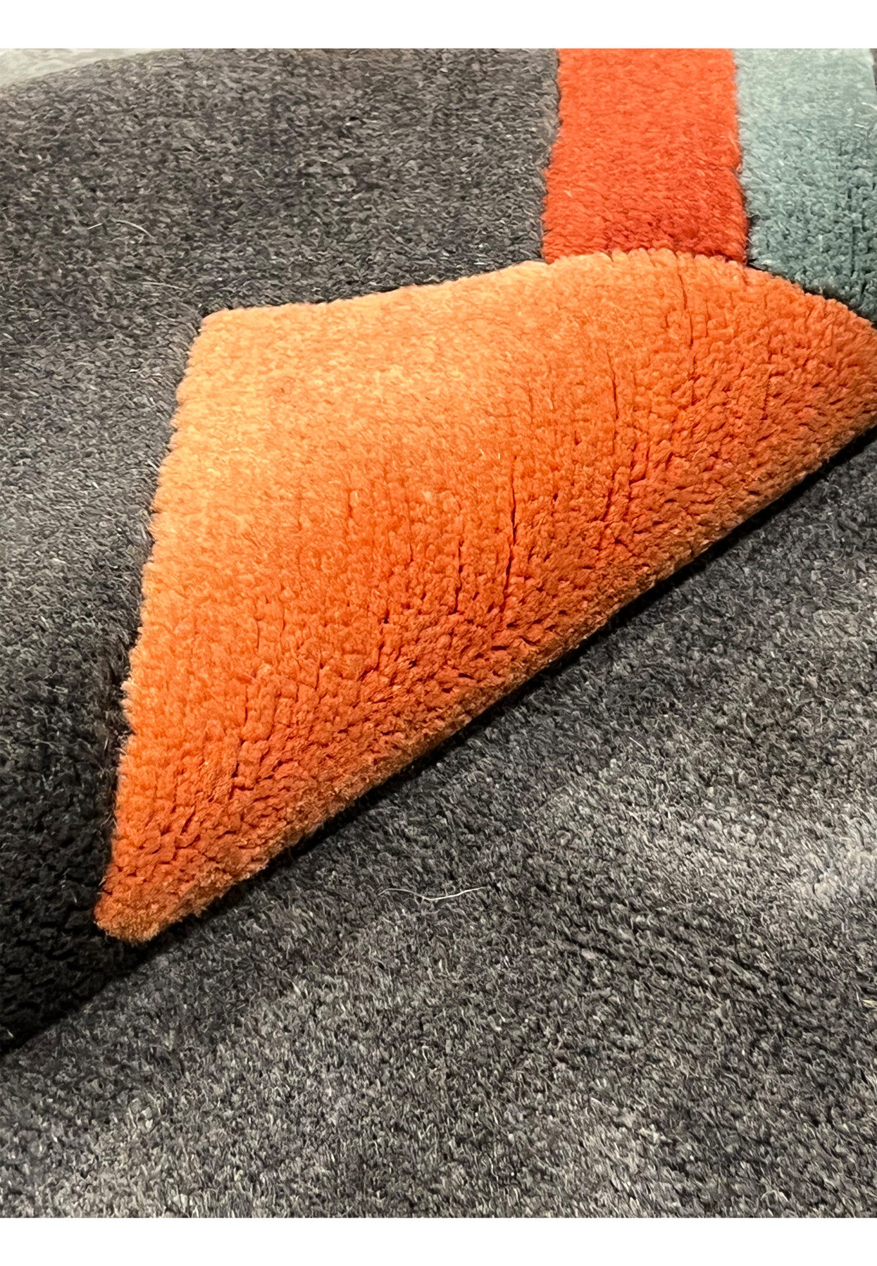 Rolled view of Gabbeh rug showing thickness, flexible wool foundation, and dense hand-knotted structure