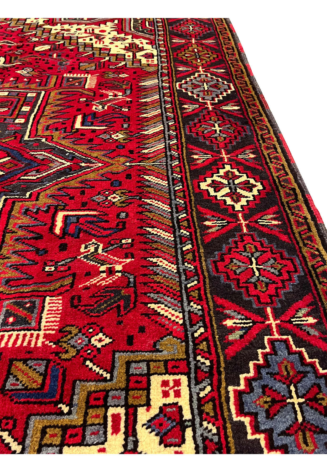 6'4 x 10'1 Persian Heriz rug angled side view showing thick wool pile, bold geometric medallion, red field, tribal border and dense hand knotted texture