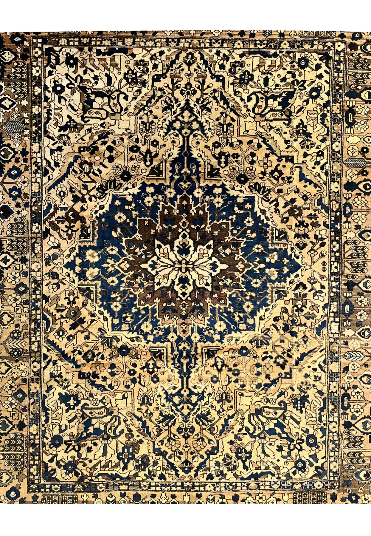 Close view of vintage Persian Heriz rug midfield showing navy medallion on ivory field with geometric floral motifs and muted wool tones