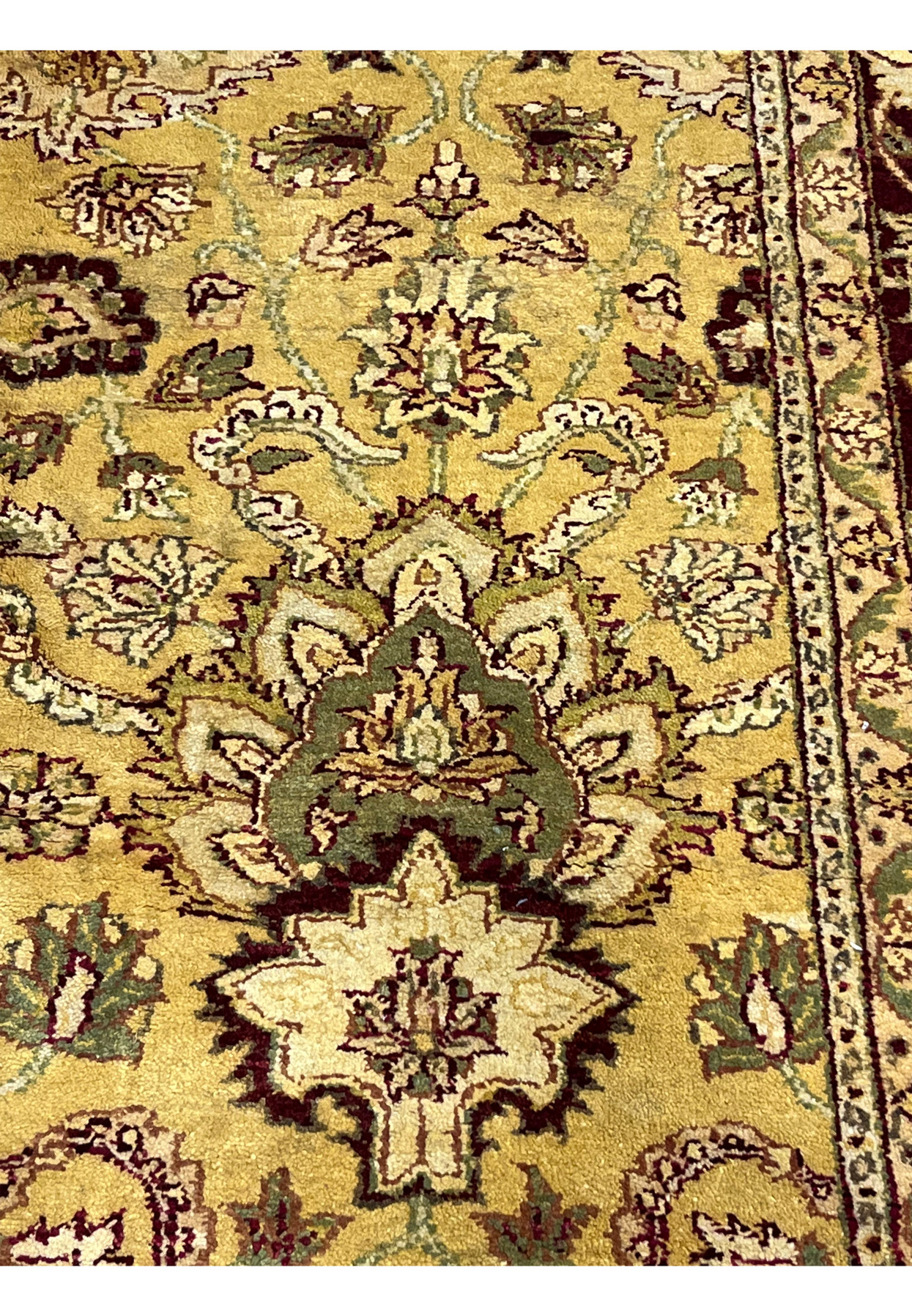 Detailed pattern section of 9x12 gold Agra rug featuring symmetrical floral elements and scrolling vines on warm mustard background.