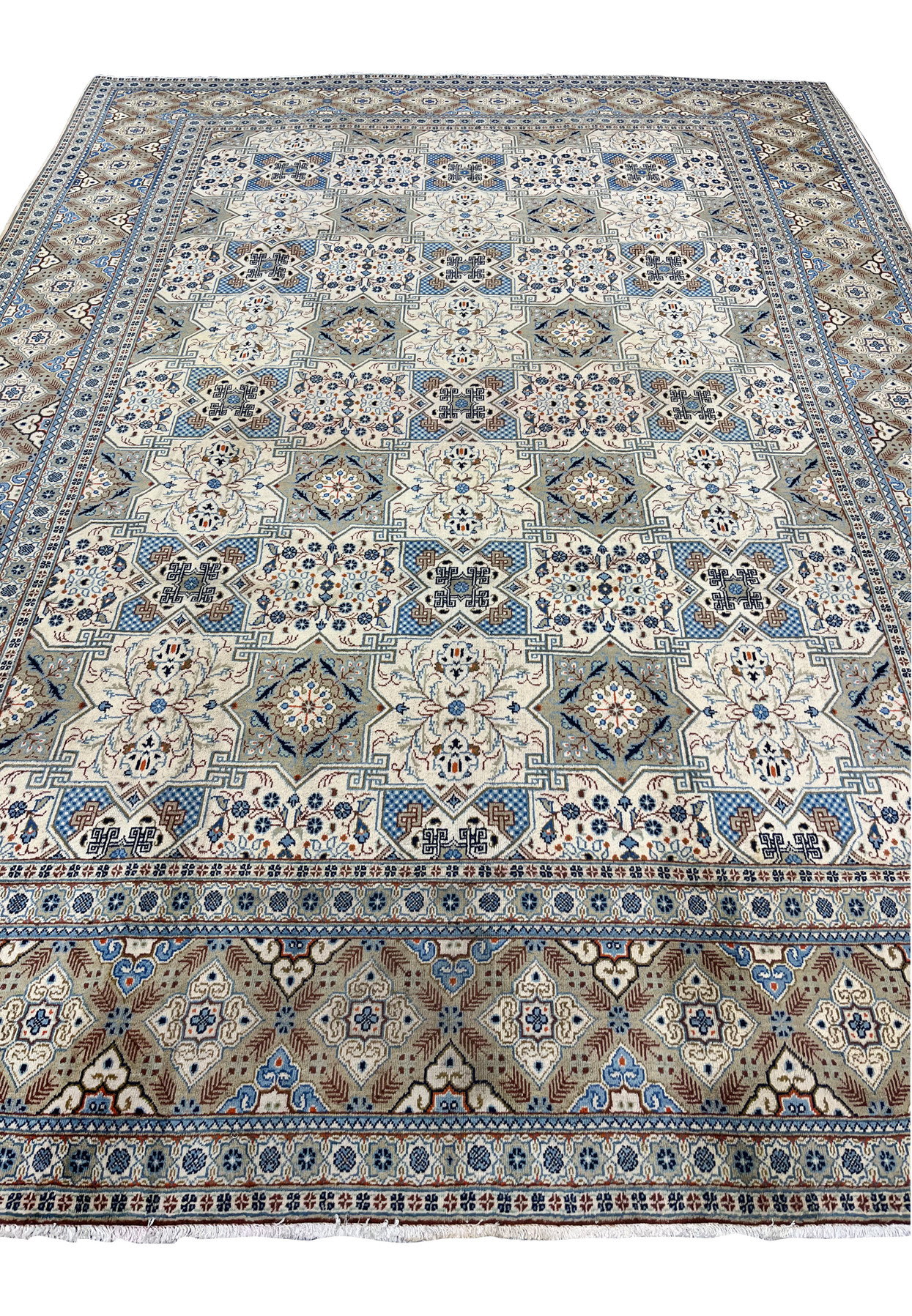 Close-up detail of the central field of a Persian Tabriz rug, revealing the intricate floral bouquets inside ivory star medallions, blue-and-white checkerboard diamond interstices, and angular Greek-key motifs connecting the compartments.