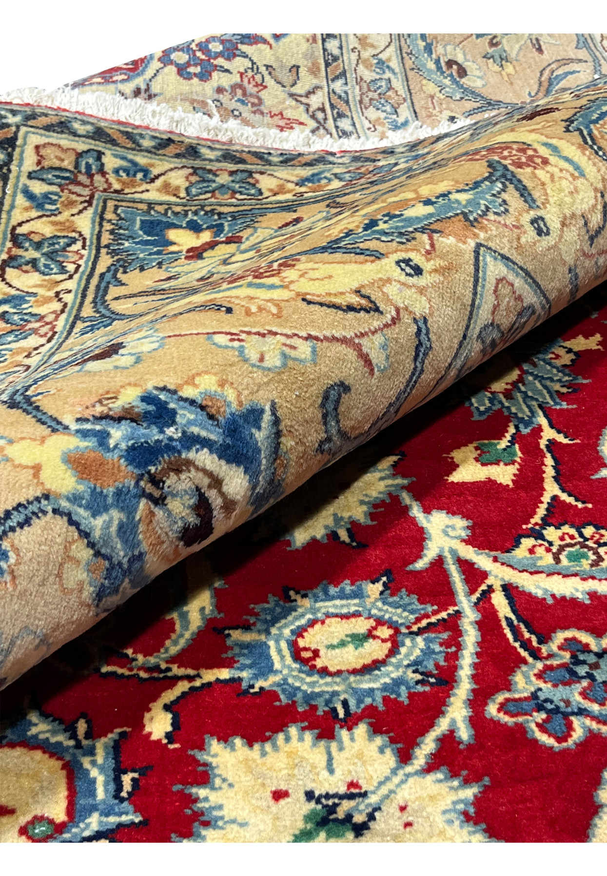 Rolled 10x13 Persian Isfahan wool rug showing pile depth ivory border floral arabesques crimson red field handmade