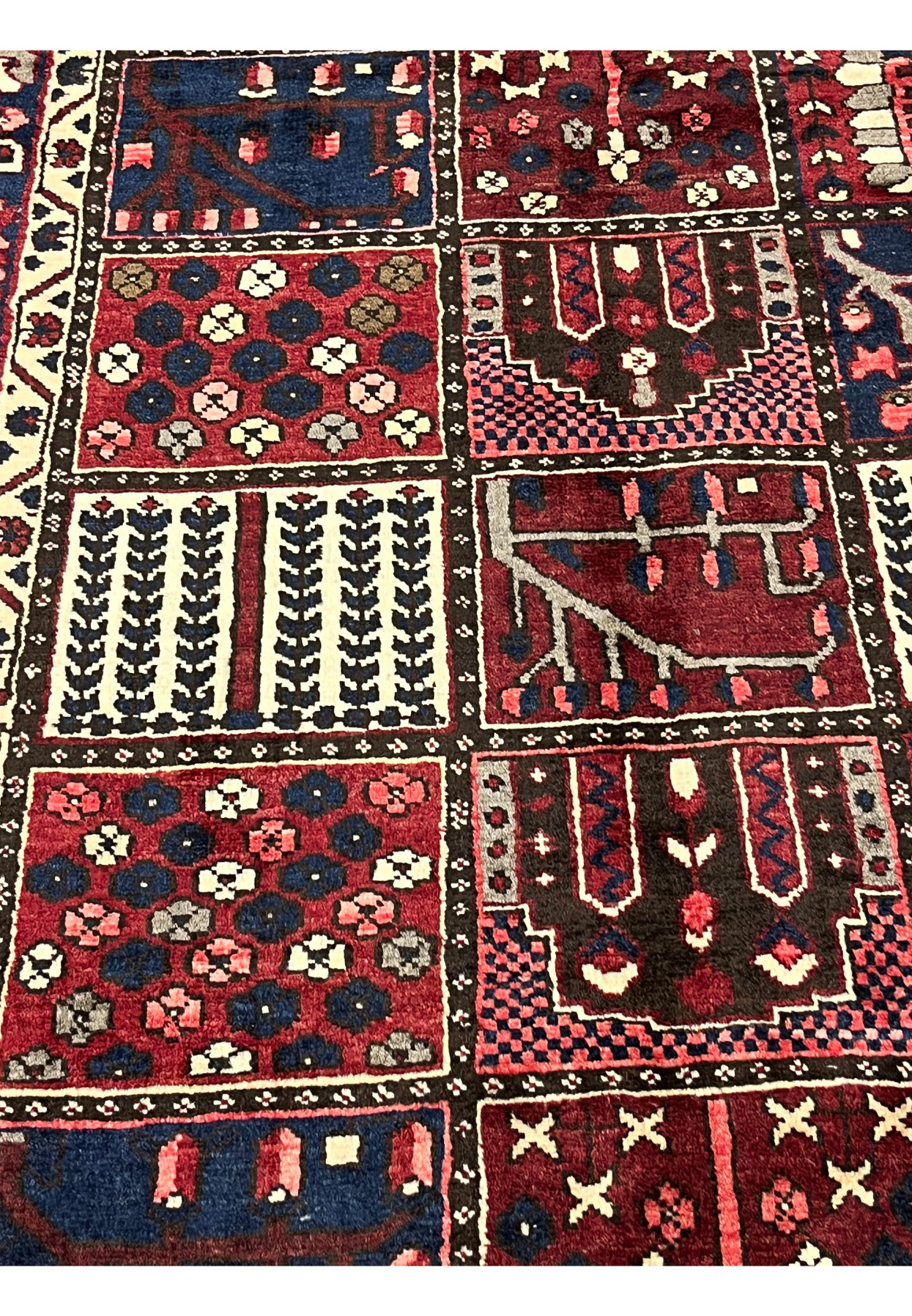 Close-up of hand-knotted khane compartments in 6'8x10 Persian Bakhtiari red and navy rug