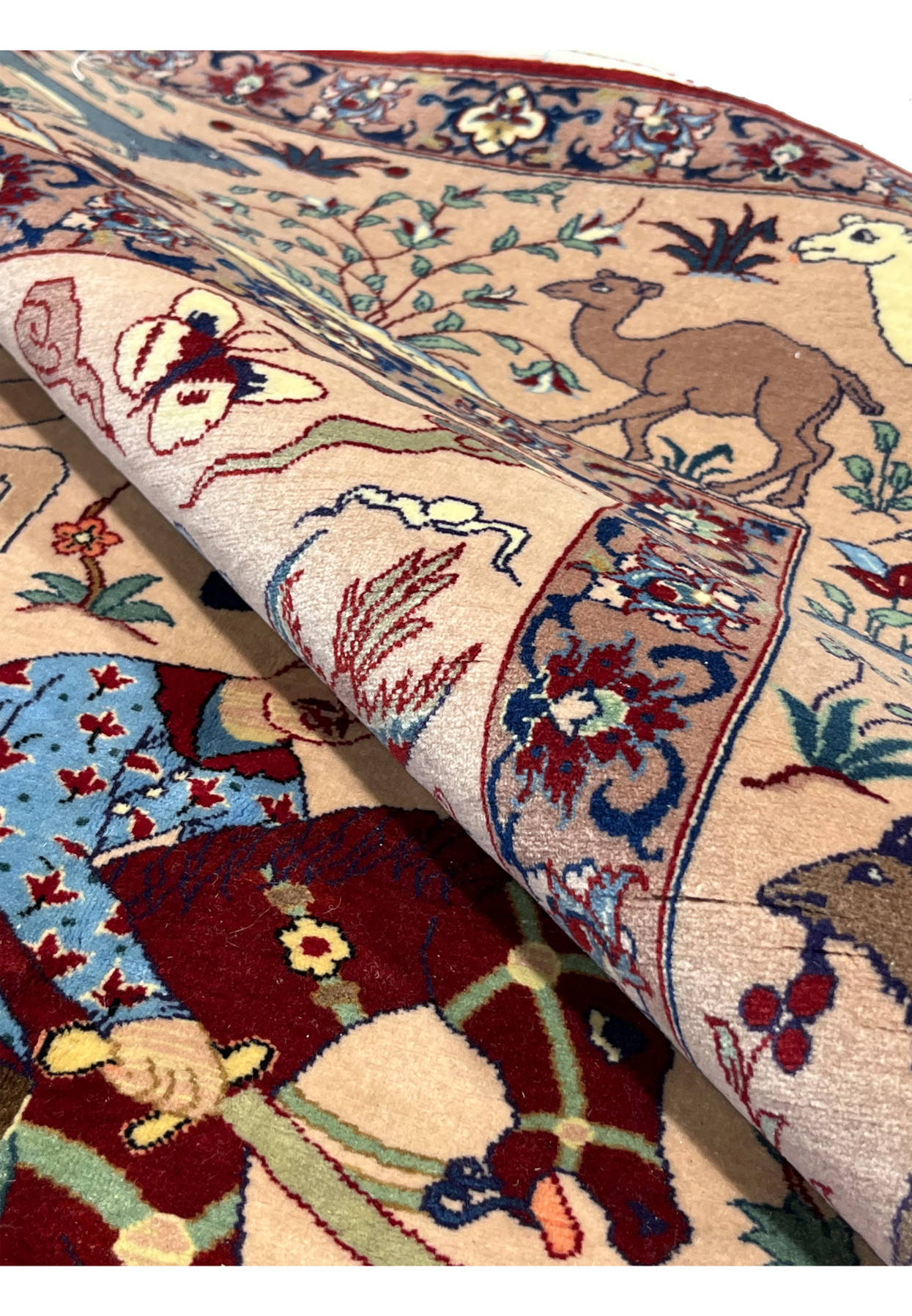 5x8 Persian Isfahan Seirafian hunting rug partially rolled showing thin silk foundation profile