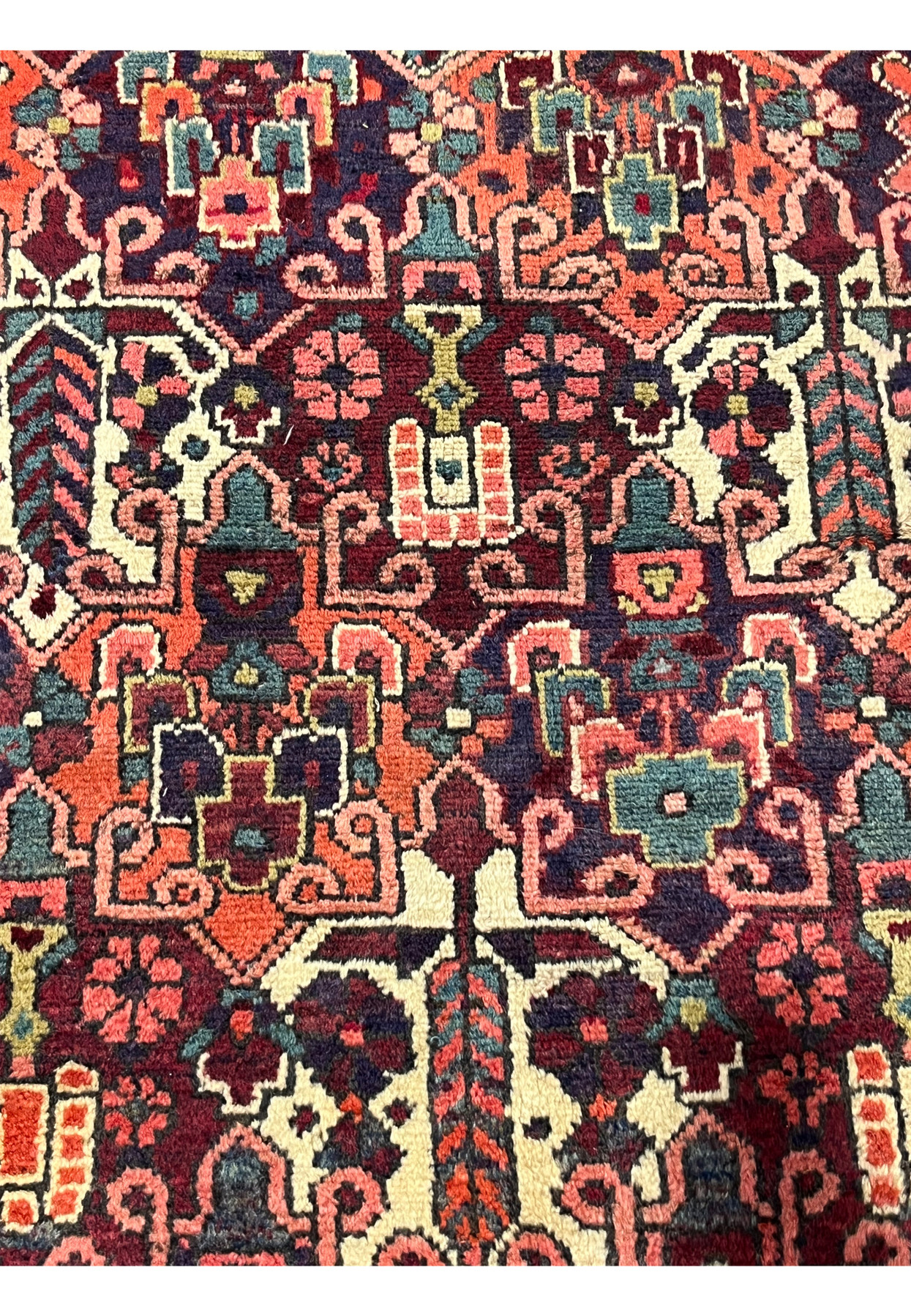 Close-up of floral motifs in antique 3'7x5 Persian Bakhtiari wool rug, navy orange teal ivory