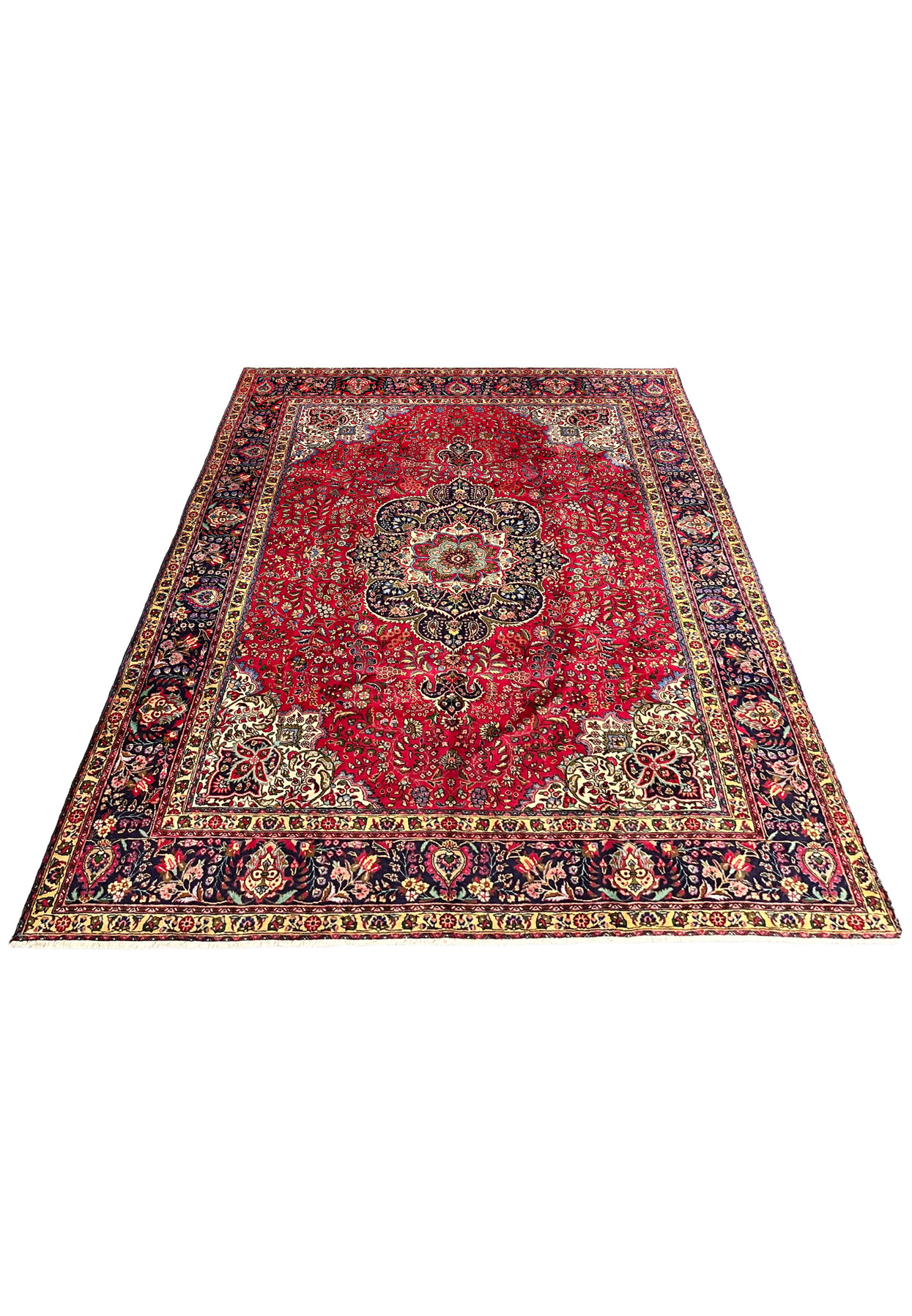 Laid down view of 10x13 Persian Tabriz rug showing full composition with red field and navy border