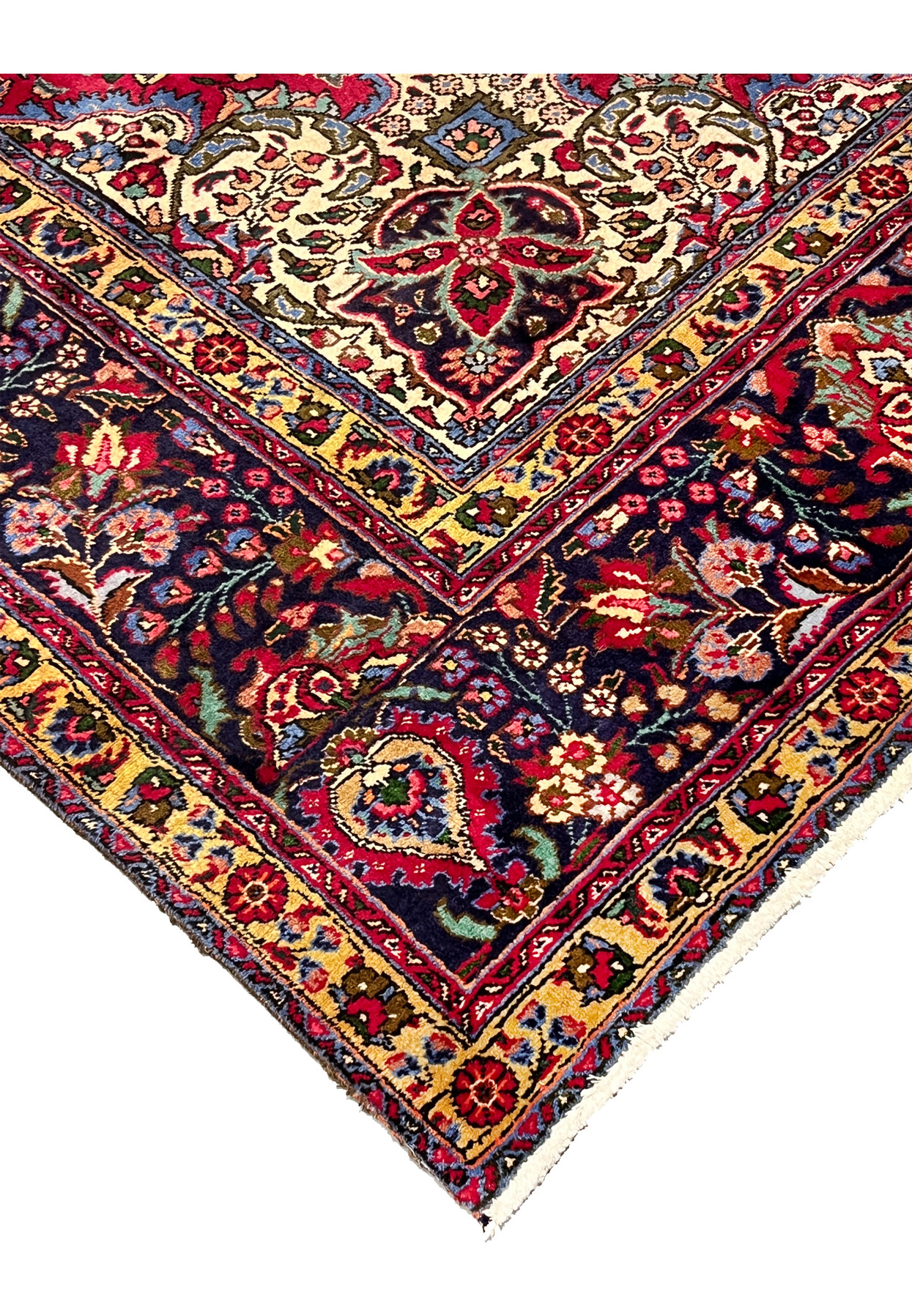 Edge view of 10x13 Persian Tabriz rug, ivory corner spandrel and navy main border