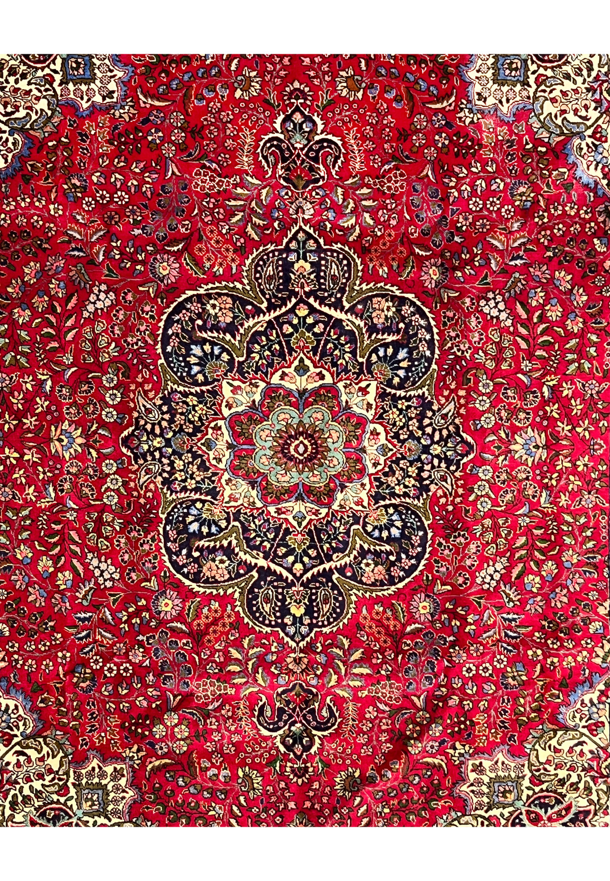 Midfield view of 10x13 Persian Tabriz rug, navy medallion with floral rosette core on red ground