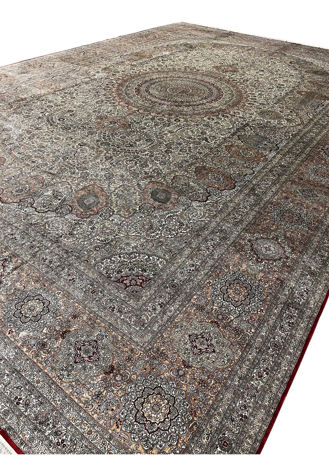 Long side profile of this 12x18 Hereke design rug with silvery ivory field and fine silk fringe