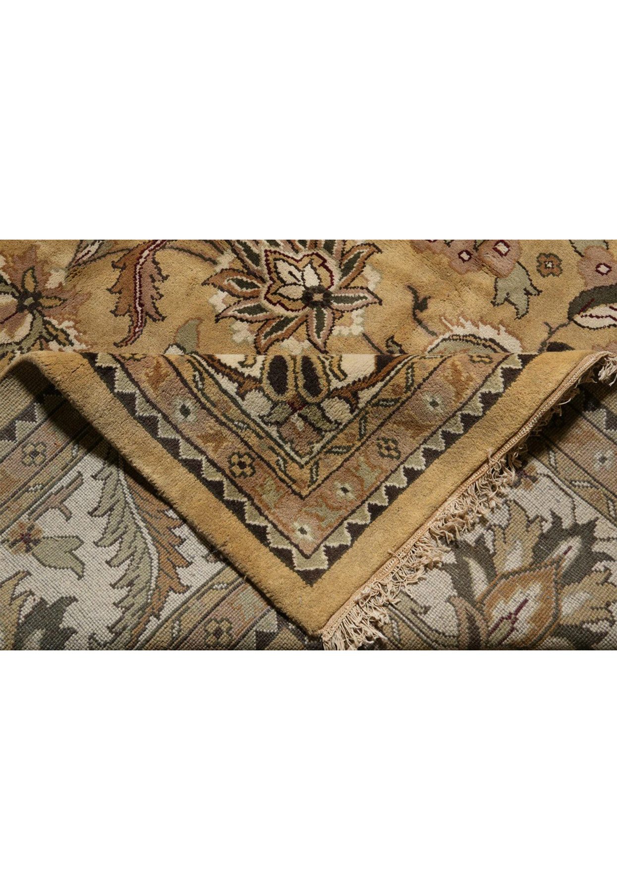 Folded edge revealing the soft hand of this hand knotted Agra wool rug on cotton foundation