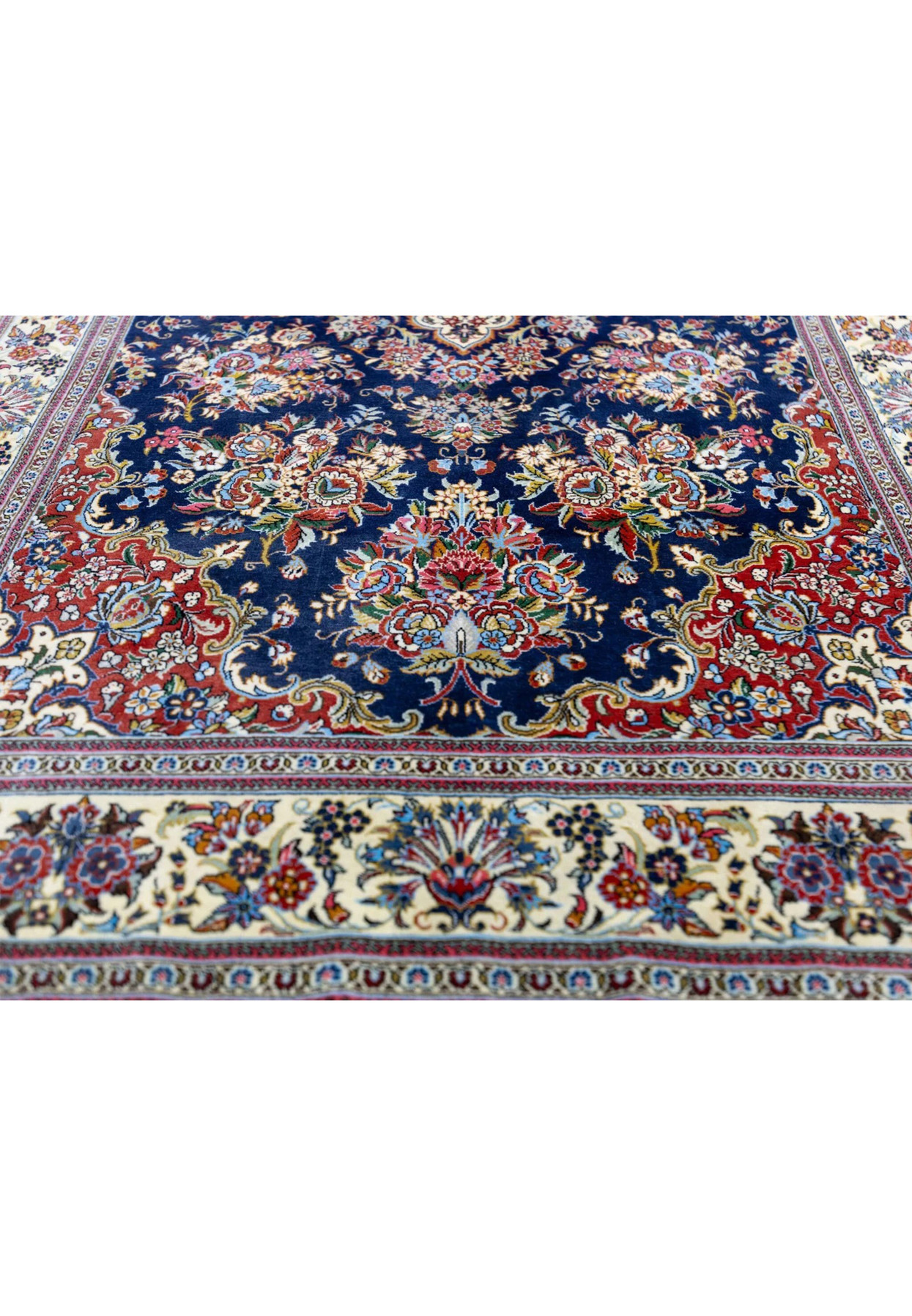 Lower field of Persian Qum kork rug showing brick red corner spandrel and floral vase bouquet motif