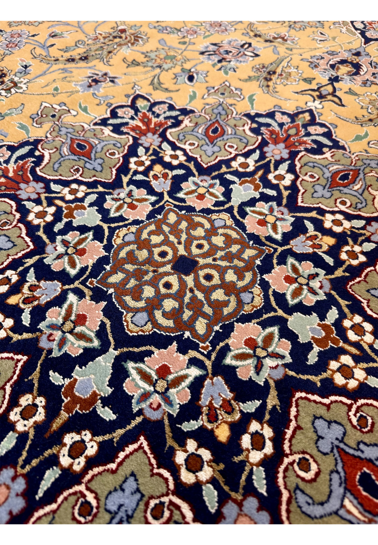 Central medallion closeup of authentic Persian Isfahan rug with intricate sage and navy floral filigree