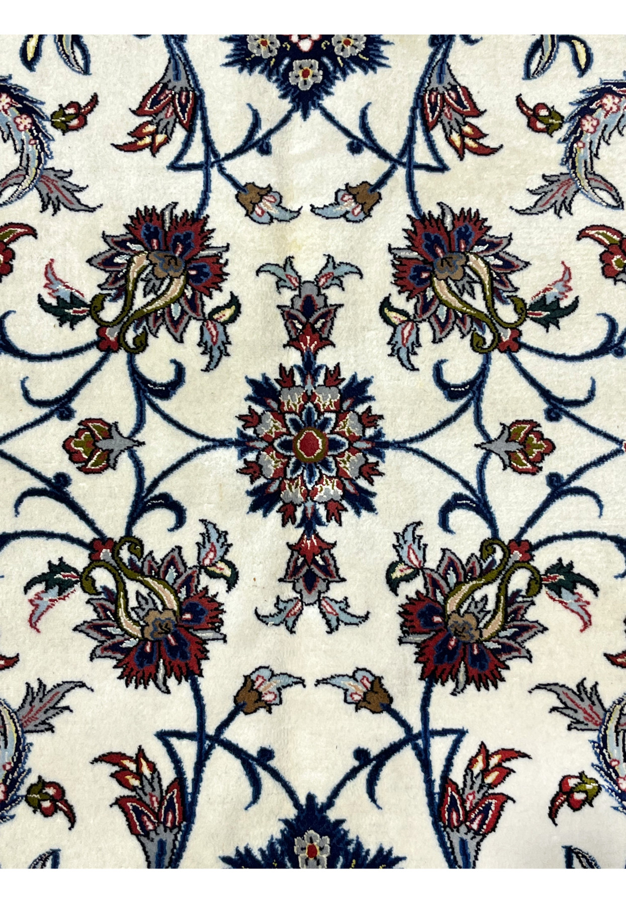 Symmetrical floral patterns and arabesque tendrils characteristic of fine signed Isfahan weaving