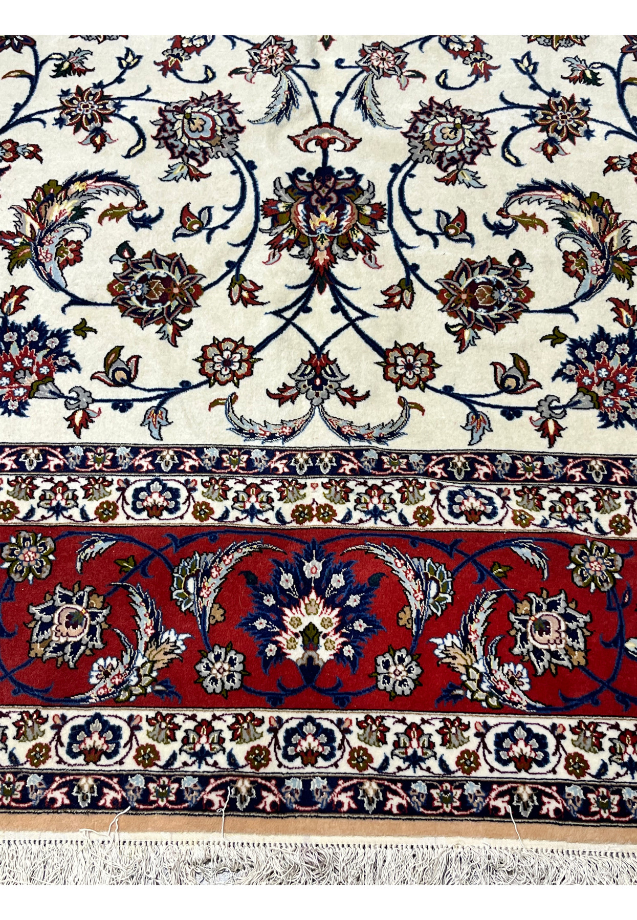 Lower border of the Isfahan rug with signature cartouche centered above the cream fringe