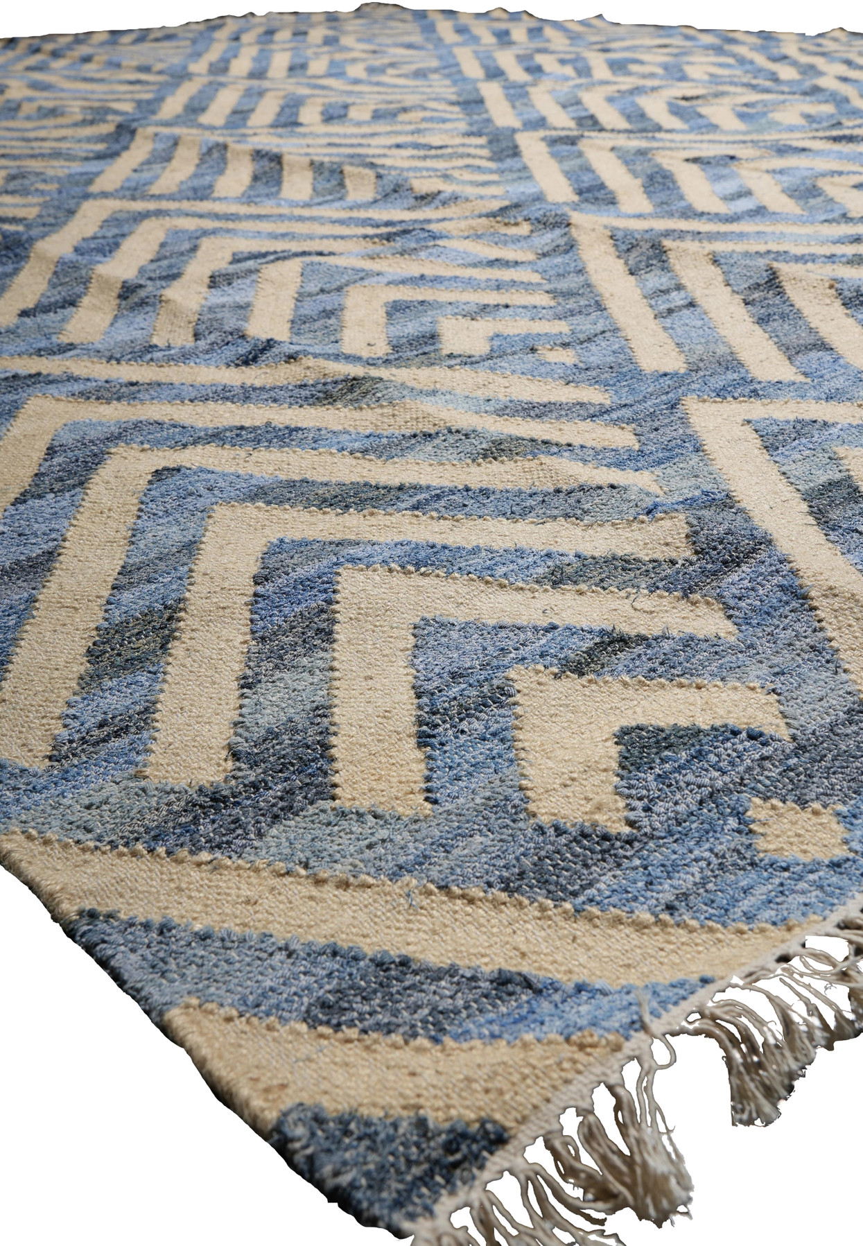 Angled perspective view of the modern kilim laid flat showing maze geometry receding toward the fringed end