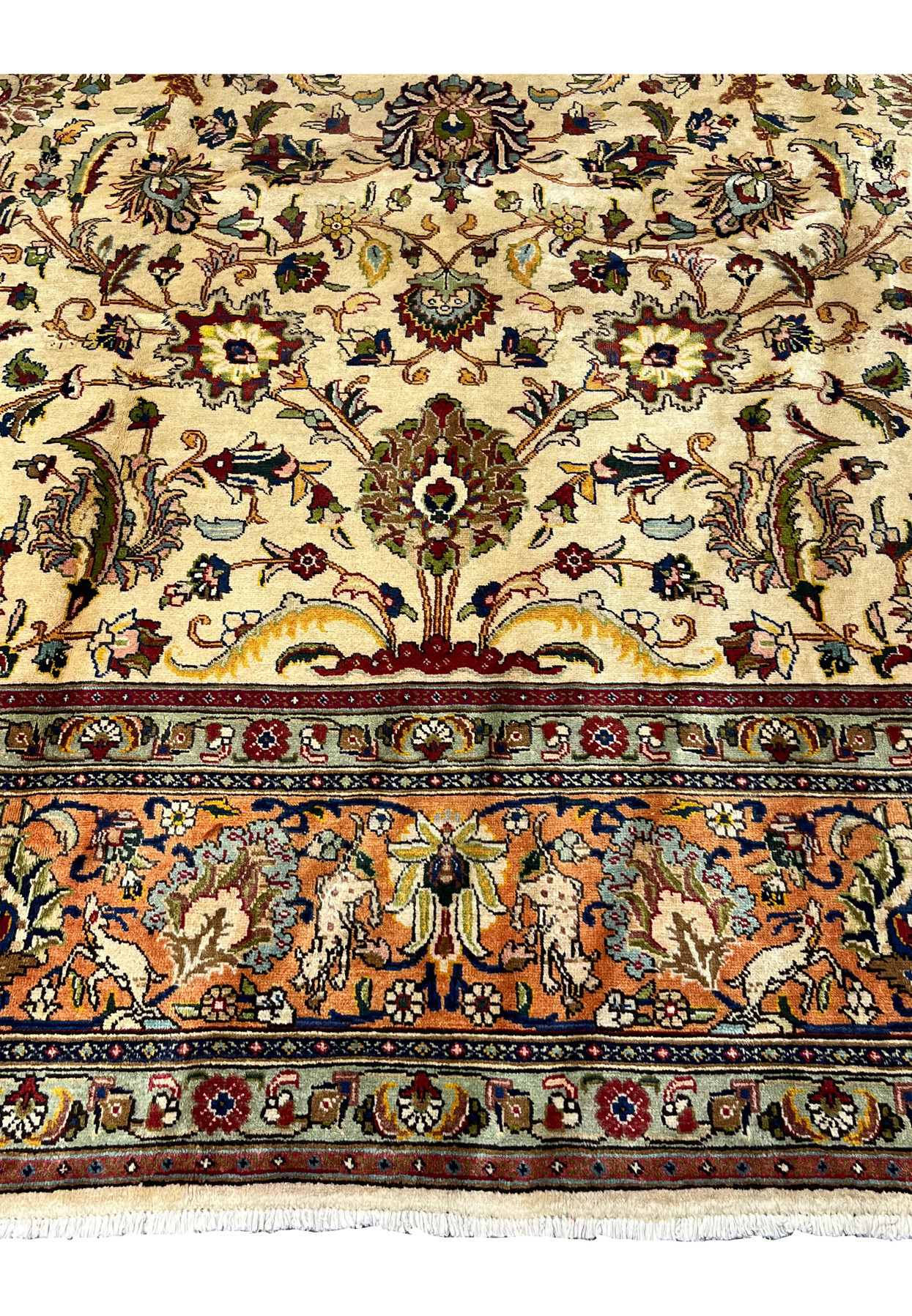 Top center detail of the Tabriz showing palmettes saz leaves and the animal figure border with stylized hares and deer