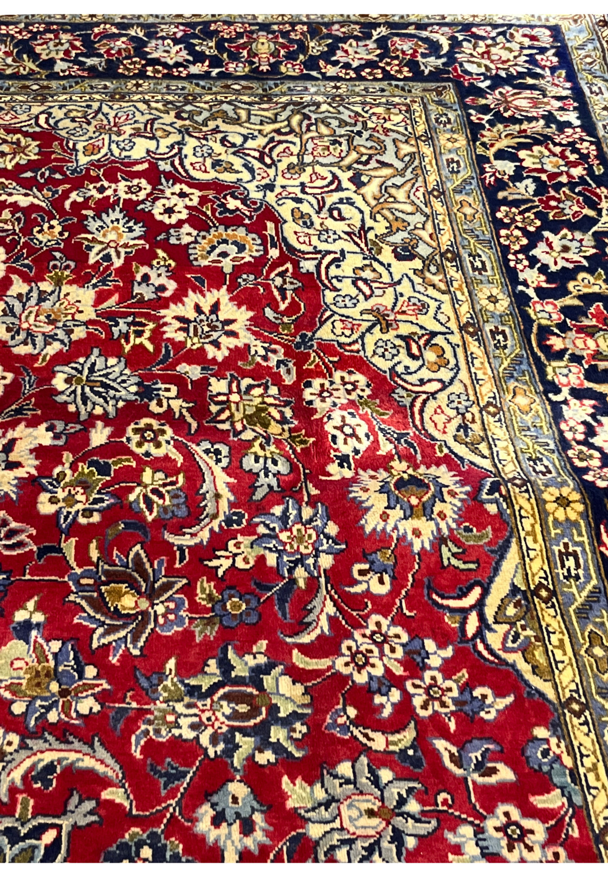 Detail view of corner spandrel and inner border showing color depth and the precision of fine workshop knotting