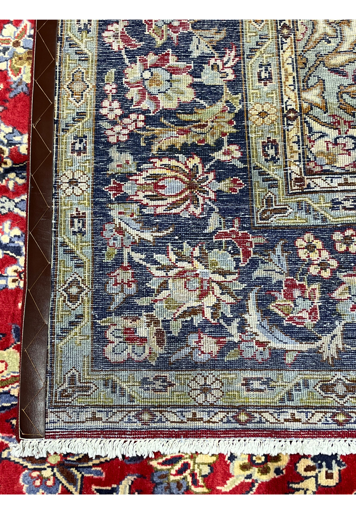 Reverse side detail with red ground and ivory border visible from the back showing the tight cotton foundation structure