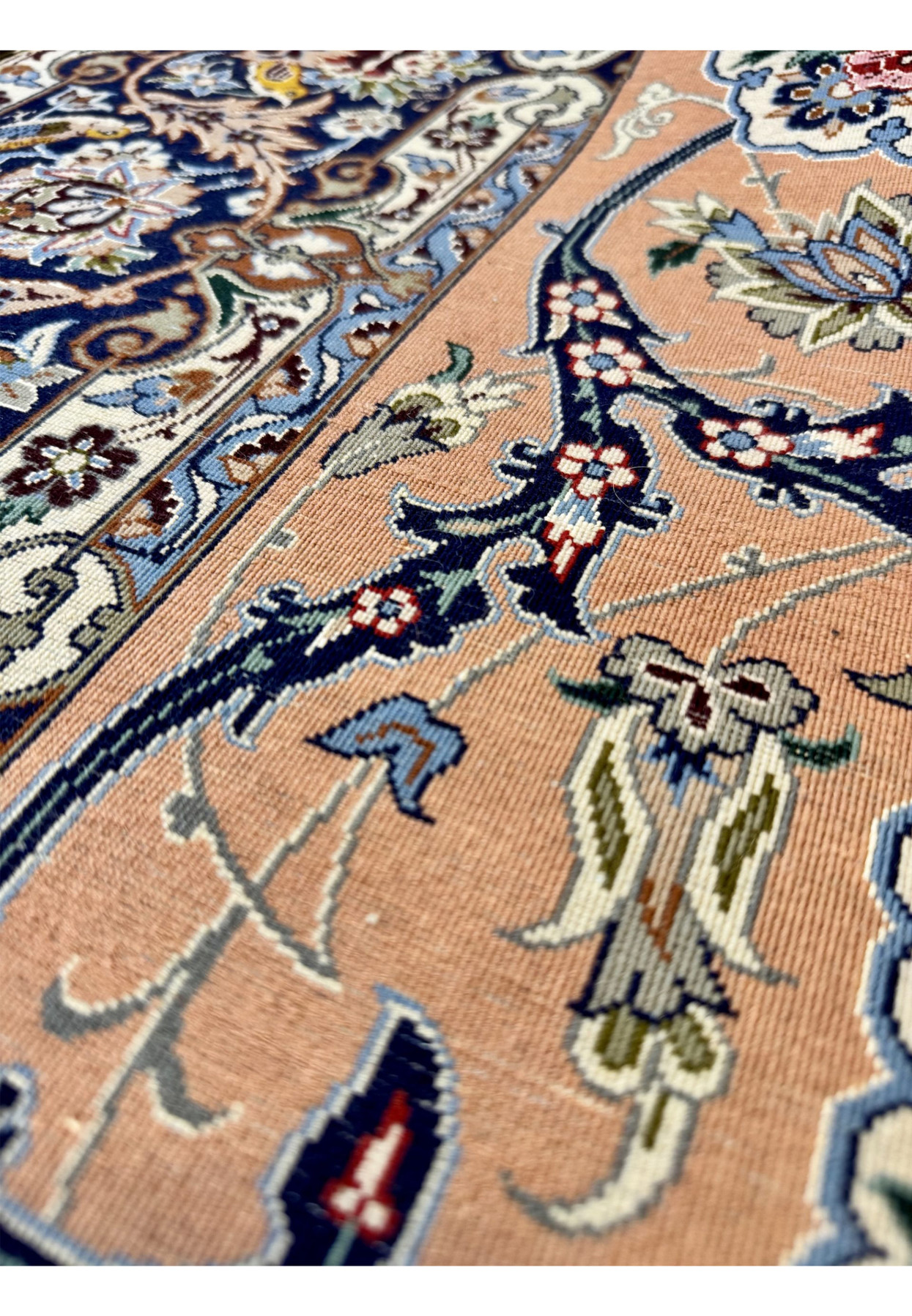 Macro back view of the Isfahan showing knot definition on the silk warp with the salmon field and floral motifs visible from the reverse