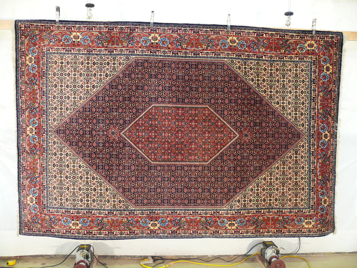 Hanging full view of 7x10 Persian Bijar rug showing complete diamond medallion design and ornate main border