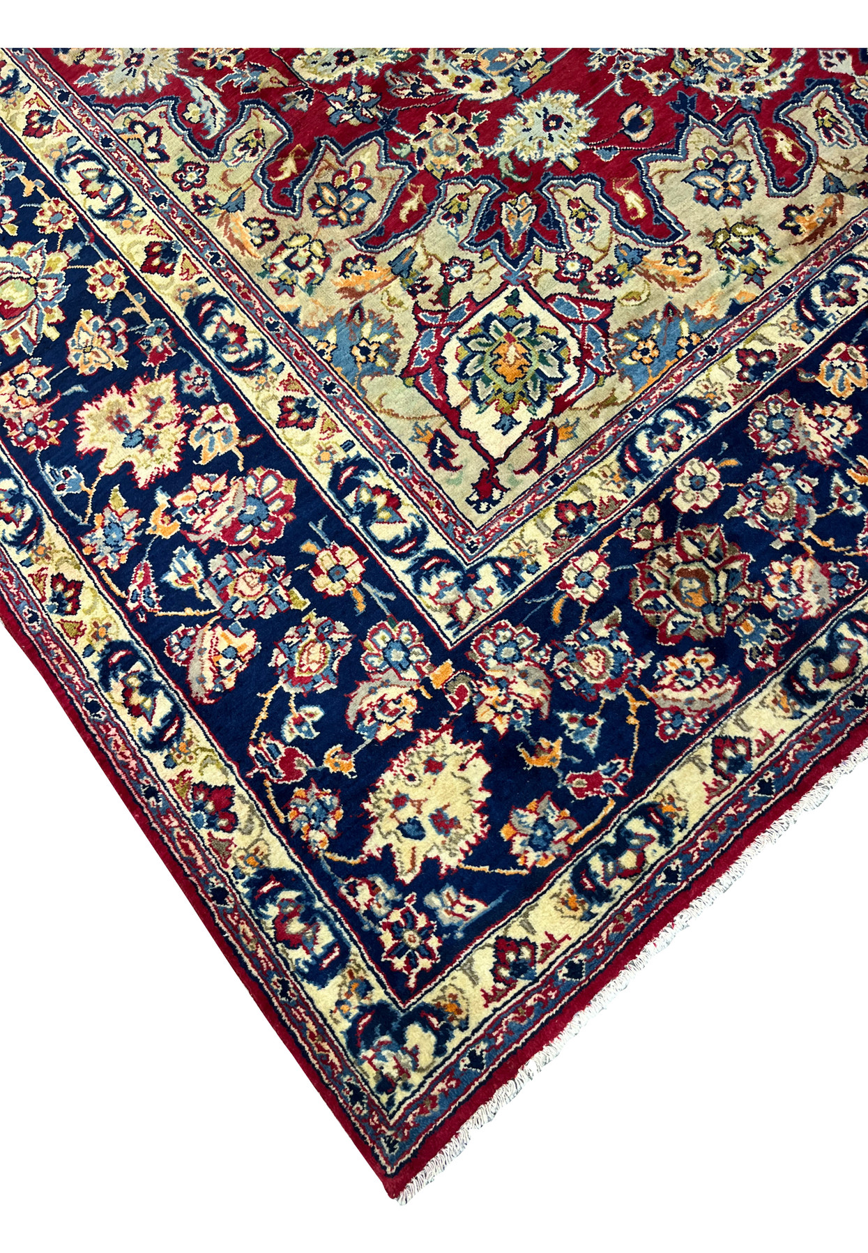 Edge detail of Persian Isfahan rug where deep red field meets navy main border with ivory floral guard band