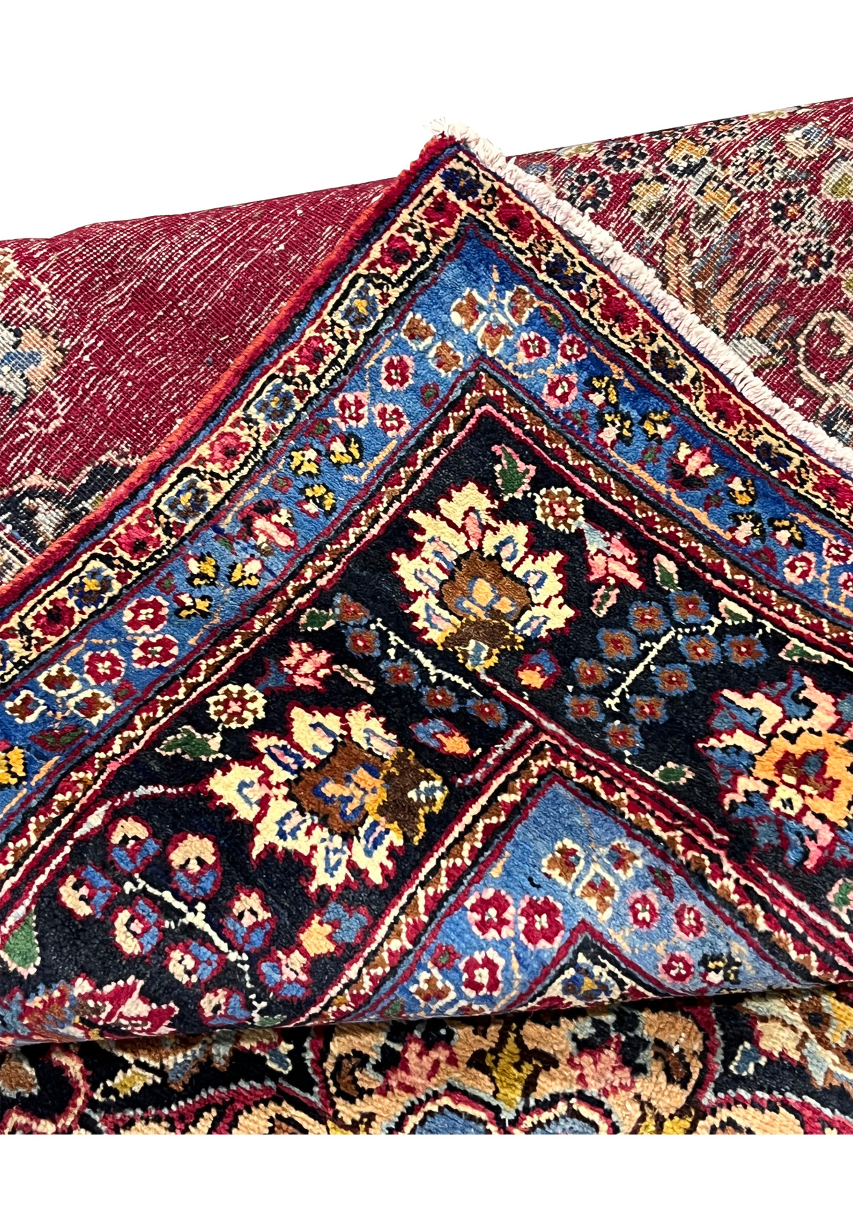 Folded edge of 8x11 Persian Kerman rug with backside detail showing fine 200 KPSI knotting and tight cotton foundation