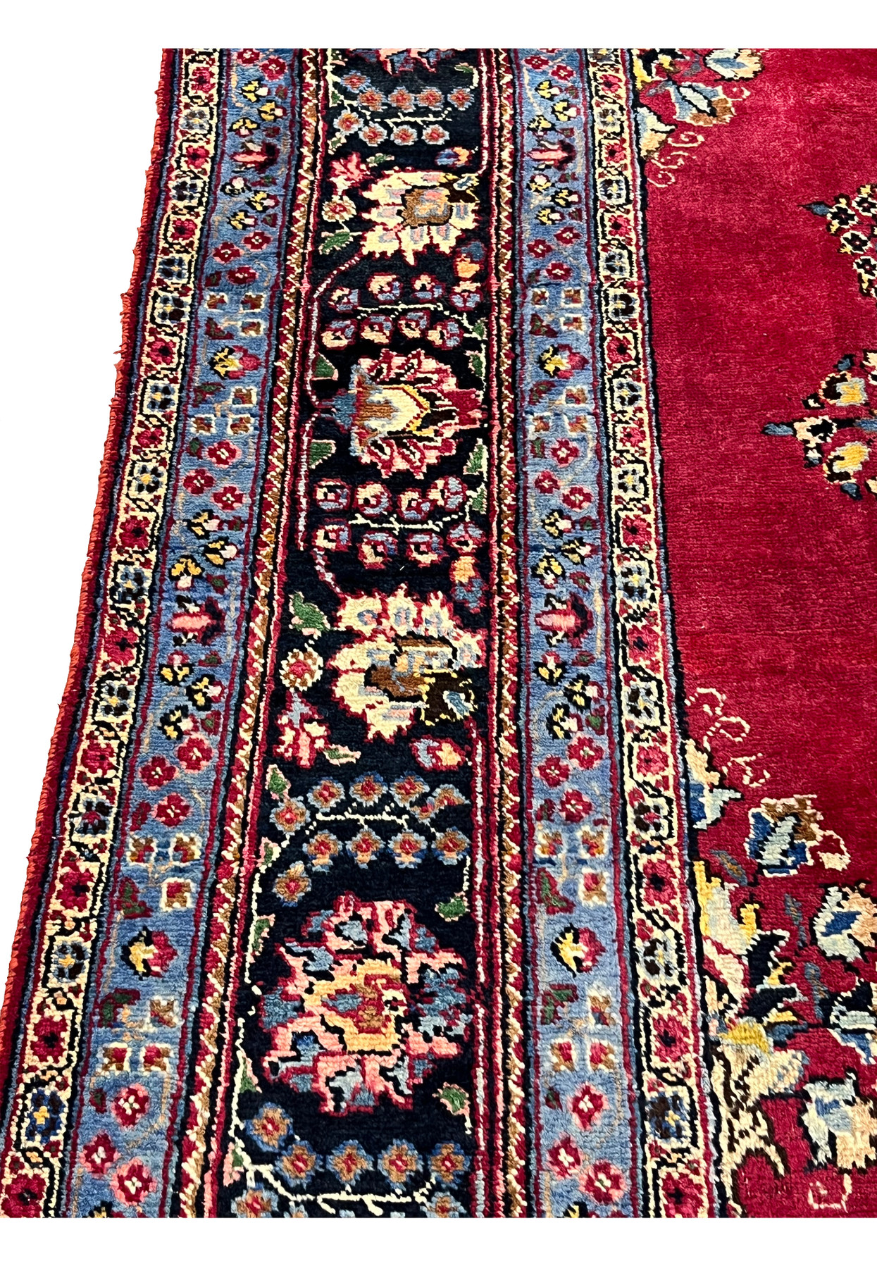 Cornflower blue minor border and navy main border detail of Persian Kerman rug with ivory and pink rosette repeats