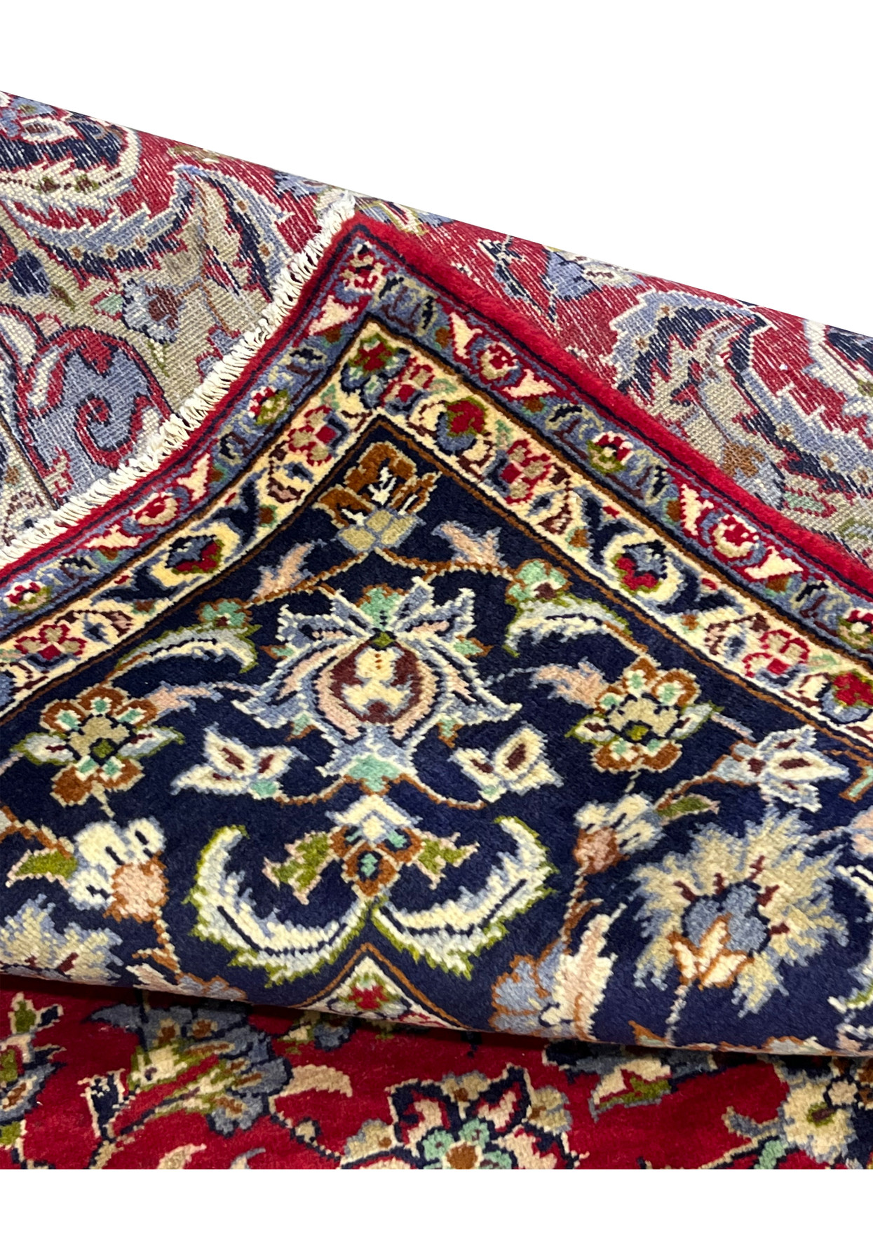 Folded edge of 9x12 Persian Isfahan rug with backside detail showing fine 240 KPSI knotting and tight cotton foundation structure