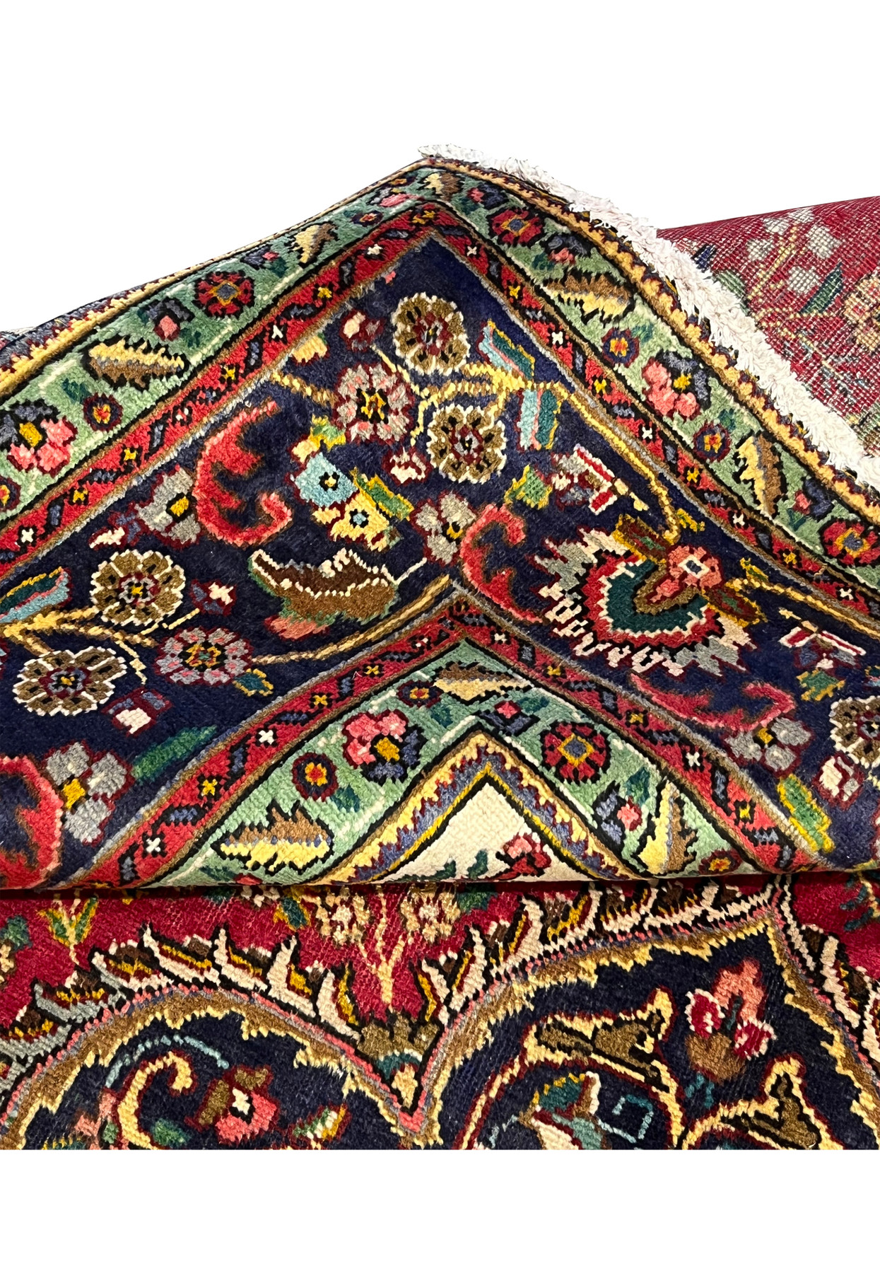 Folded edge of Persian Kerman rug with backside detail showing fine 200 KPSI knotting, cotton foundation, and tight bound selvage