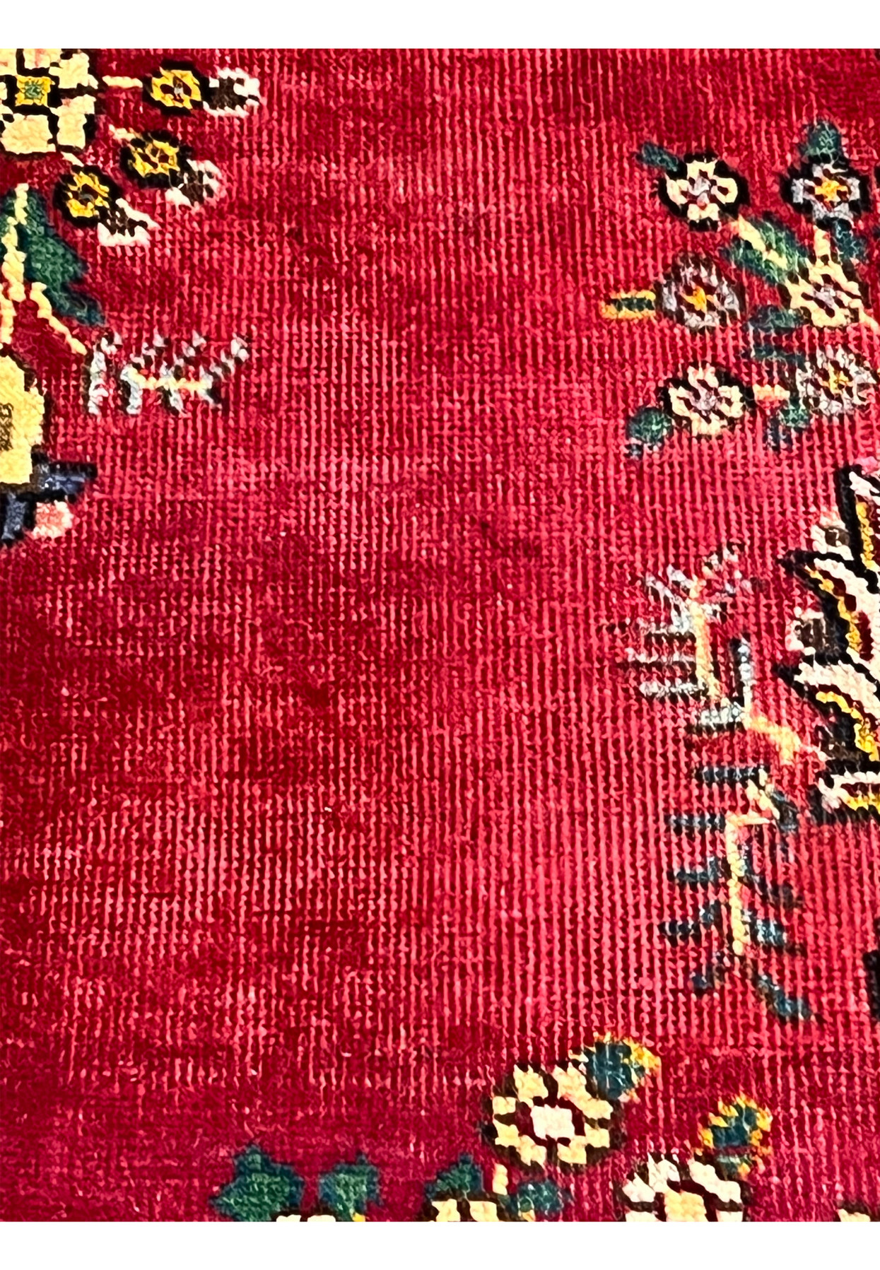 Closeup of natural abrash variation across crimson field of Persian Kerman rug showing tonal shifts from vegetable dyed wool batches