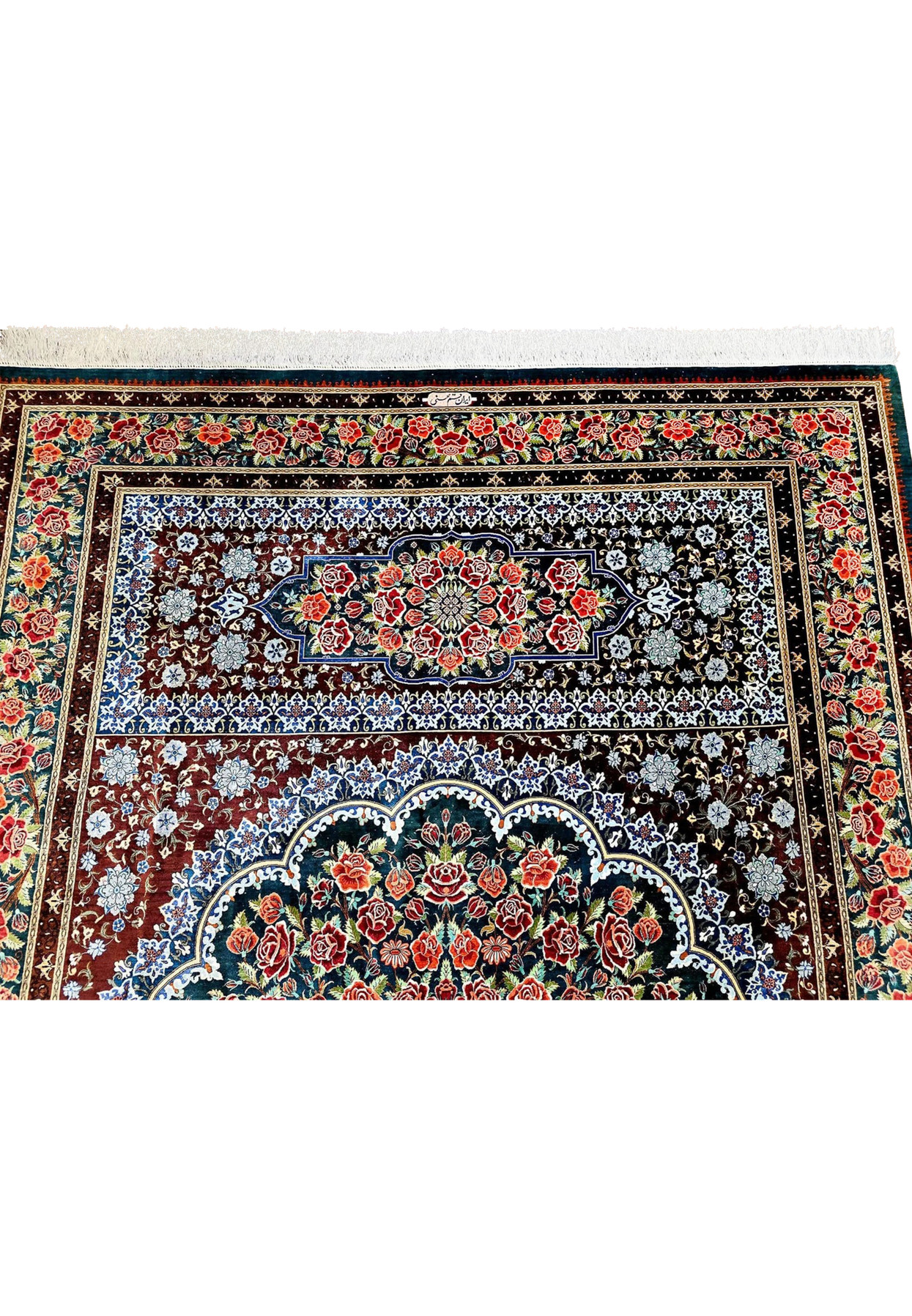 Persian Qum silk on silk rug shown from a low angle, scalloped medallion glowing against deep oxblood and navy ground