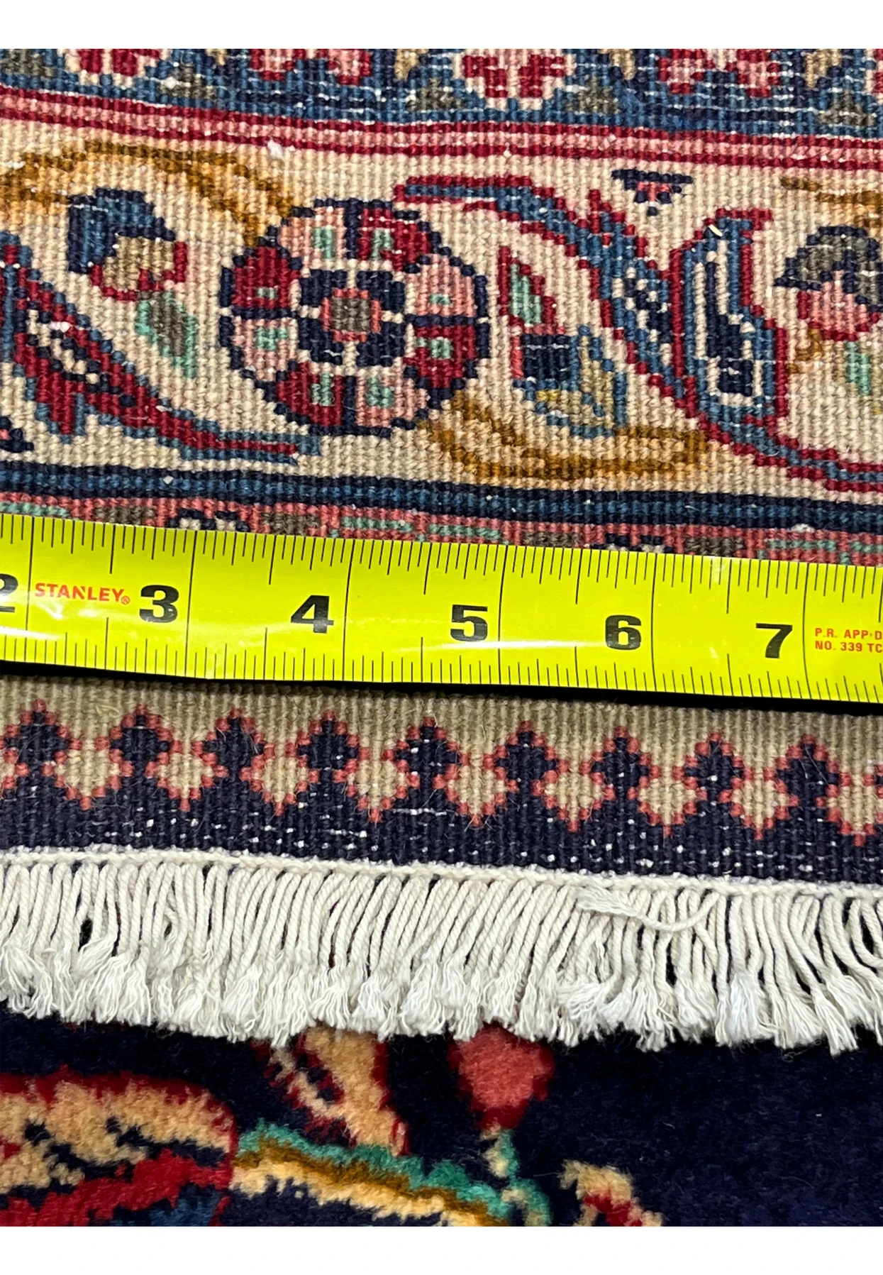 Backside knot density measurement of 10x13 Persian Qum kork rug showing approximately 280 to 300 KPSI on cotton foundation